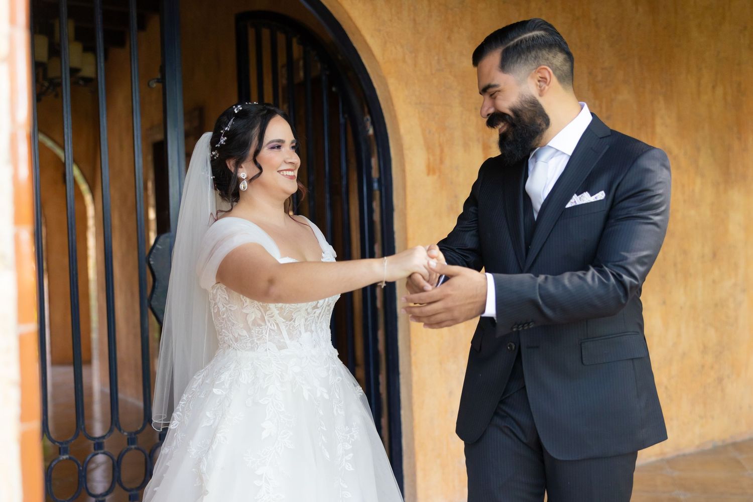 A couple shares a tender moment in front of an arched doorway during their wedding. Boda en Parras Coahuila, Fotógrafo de bodas