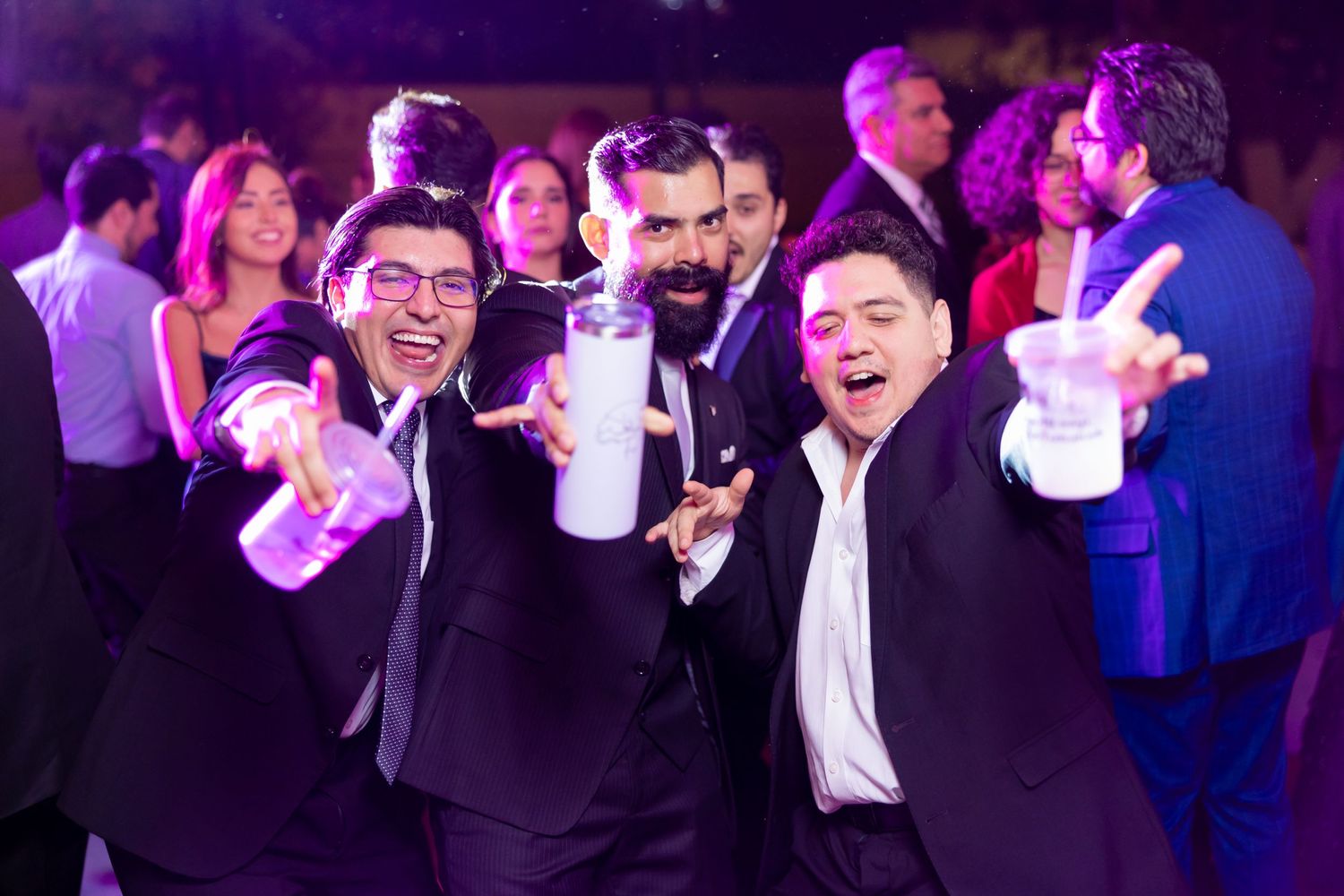 Wedding guests in formal attire pose with drinks during the reception celebration. Boda en Parras Coahuila, Fotógrafo de bodas