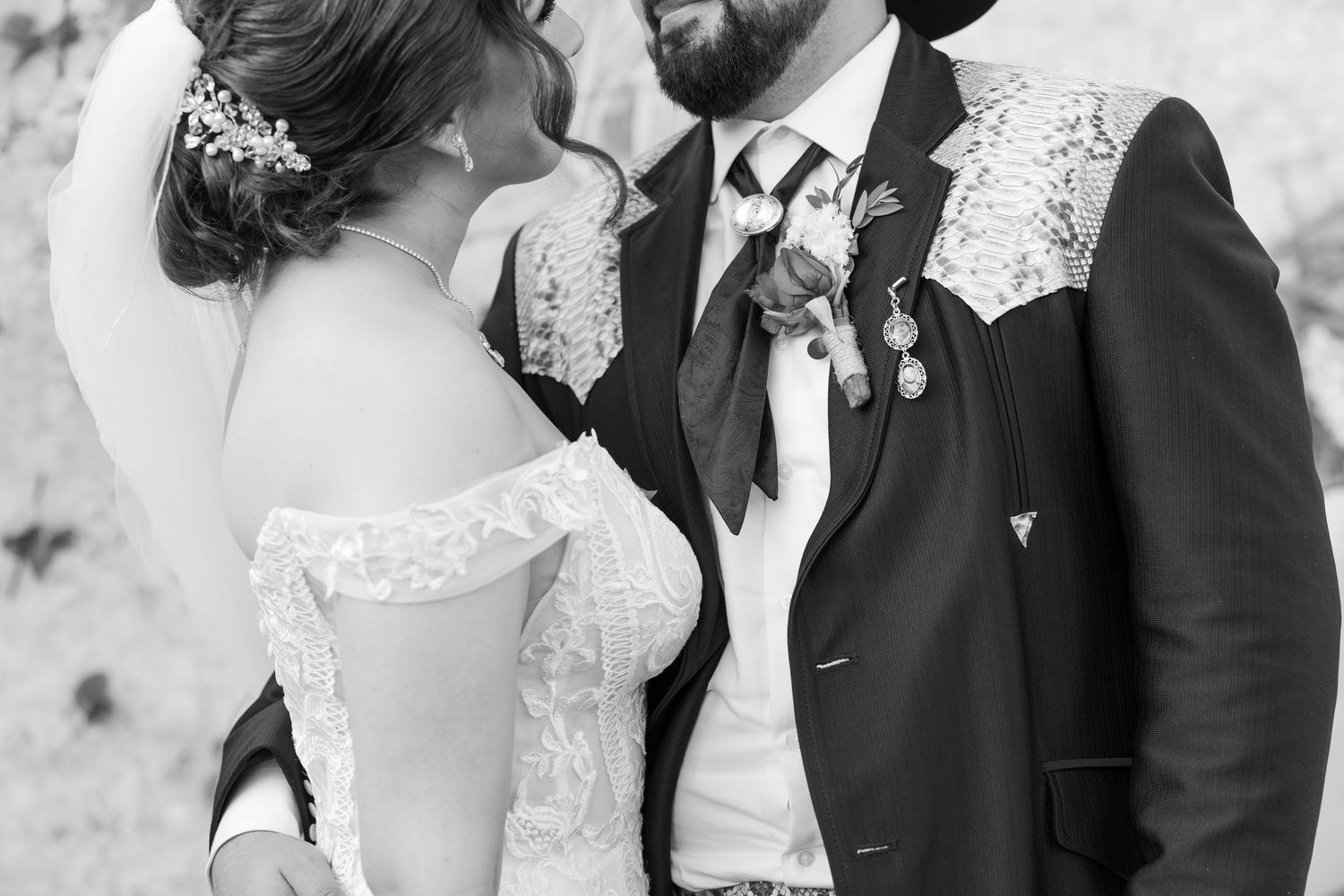 A bride and groom share a tender moment during their wedding ceremony while surrounded by guests.