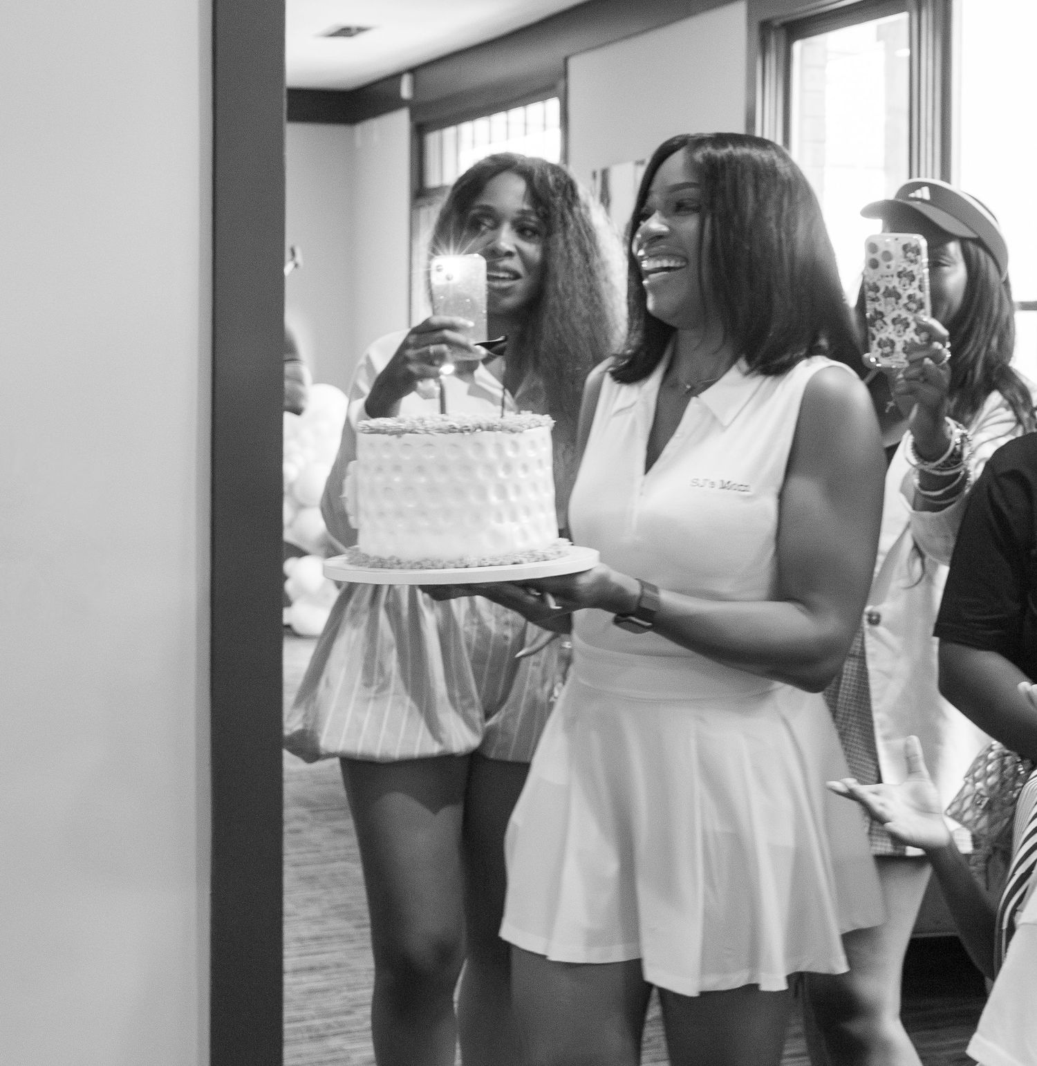 People in white outfits celebrating at a party indoors.