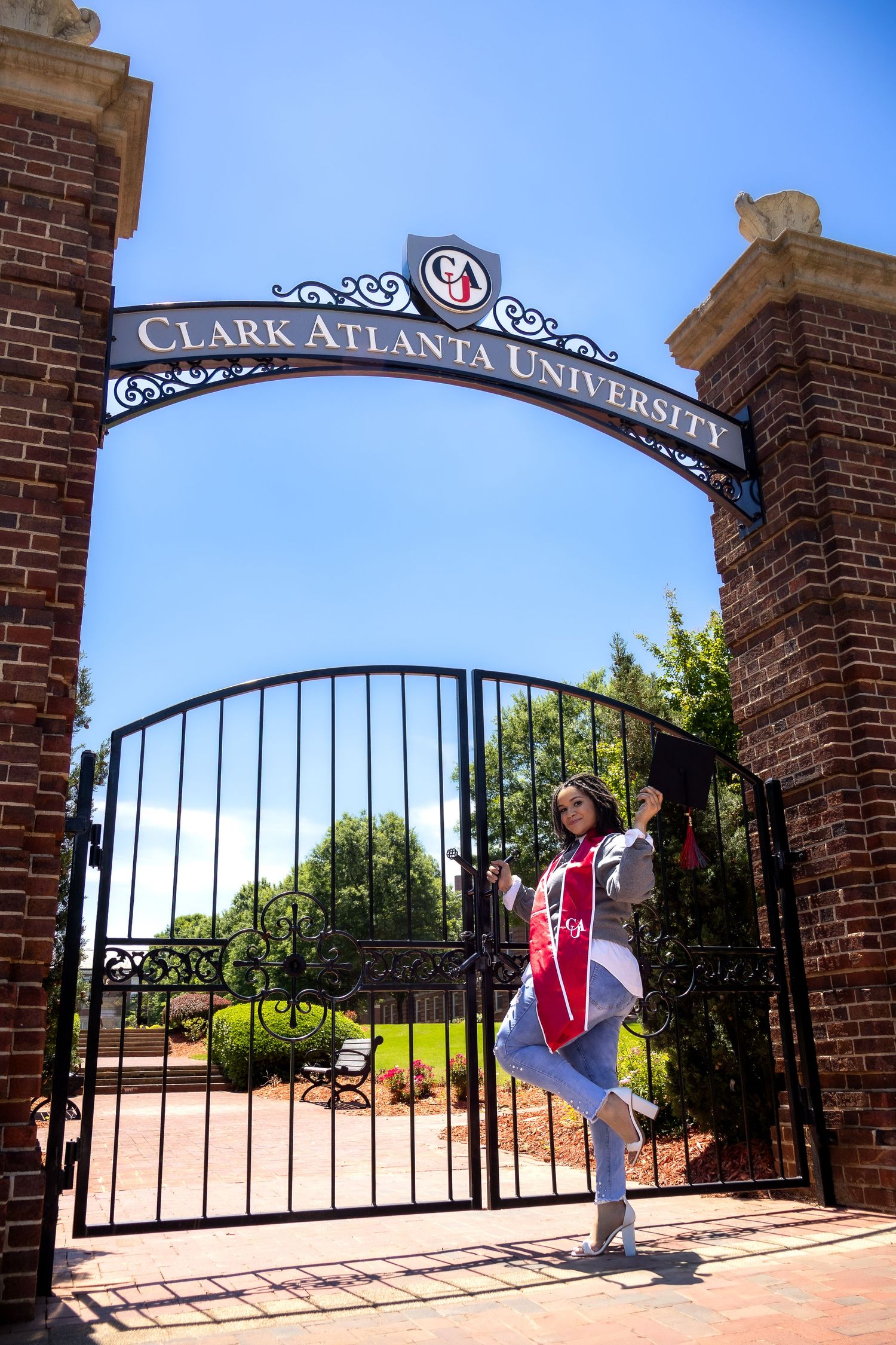 Decorative brick entrance gate with ornate sign for Clark Atlanta University against blue sky.