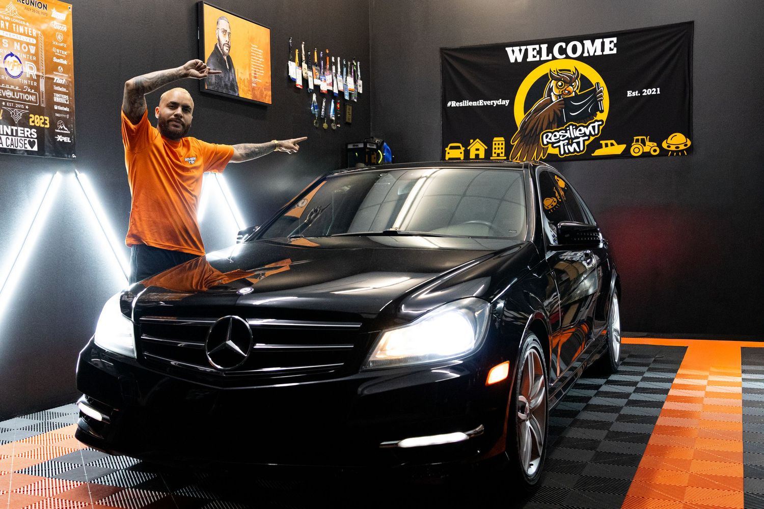 Modern auto detailing garage interior with black and orange color scheme showing luxury cars and professional lighting. marketing and busine