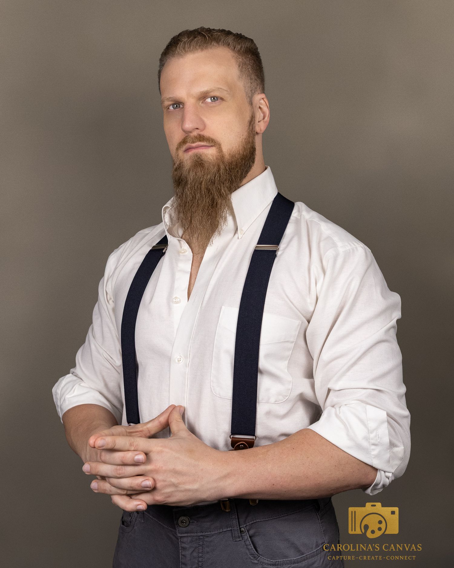 A person in a white dress shirt and navy suspenders poses from different angles against a neutral background.