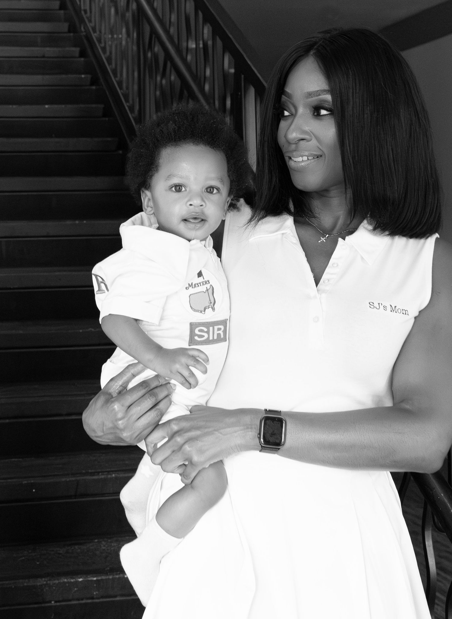 A series of black and white photographs showing tender moments between a parent and baby in matching white outfits.