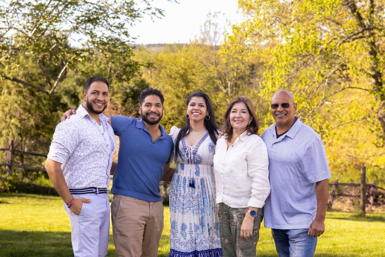 Group poses together outdoors on a sunny autumn day with golden foliage in the background.