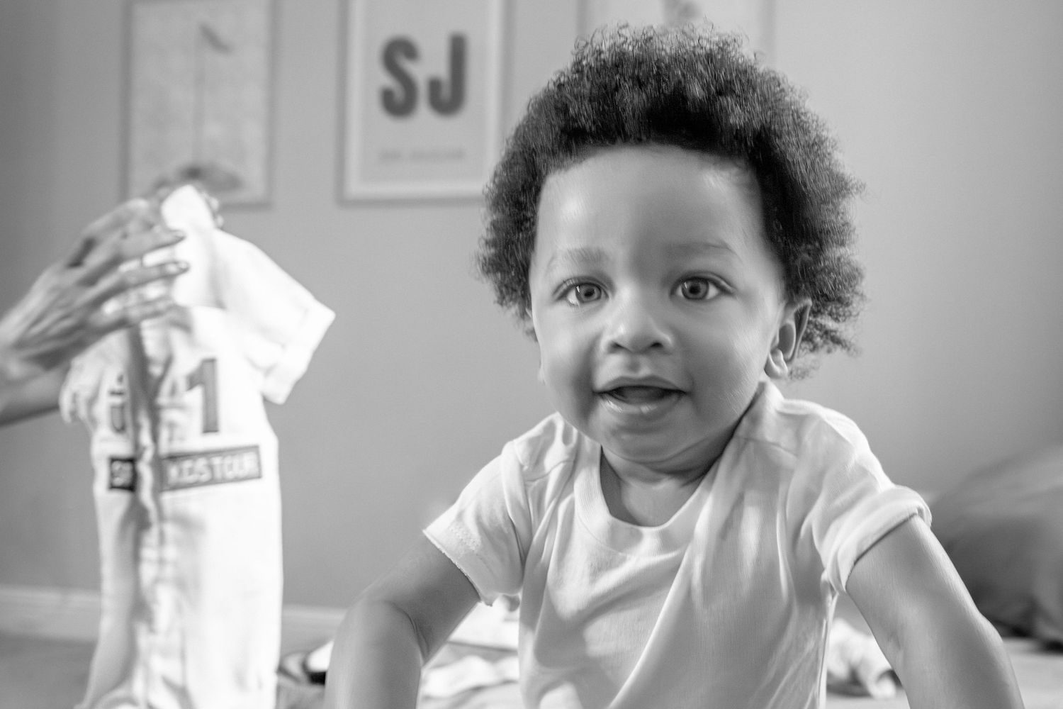 Black and white image shows a healthcare worker caring for a young patient in a clinical setting.