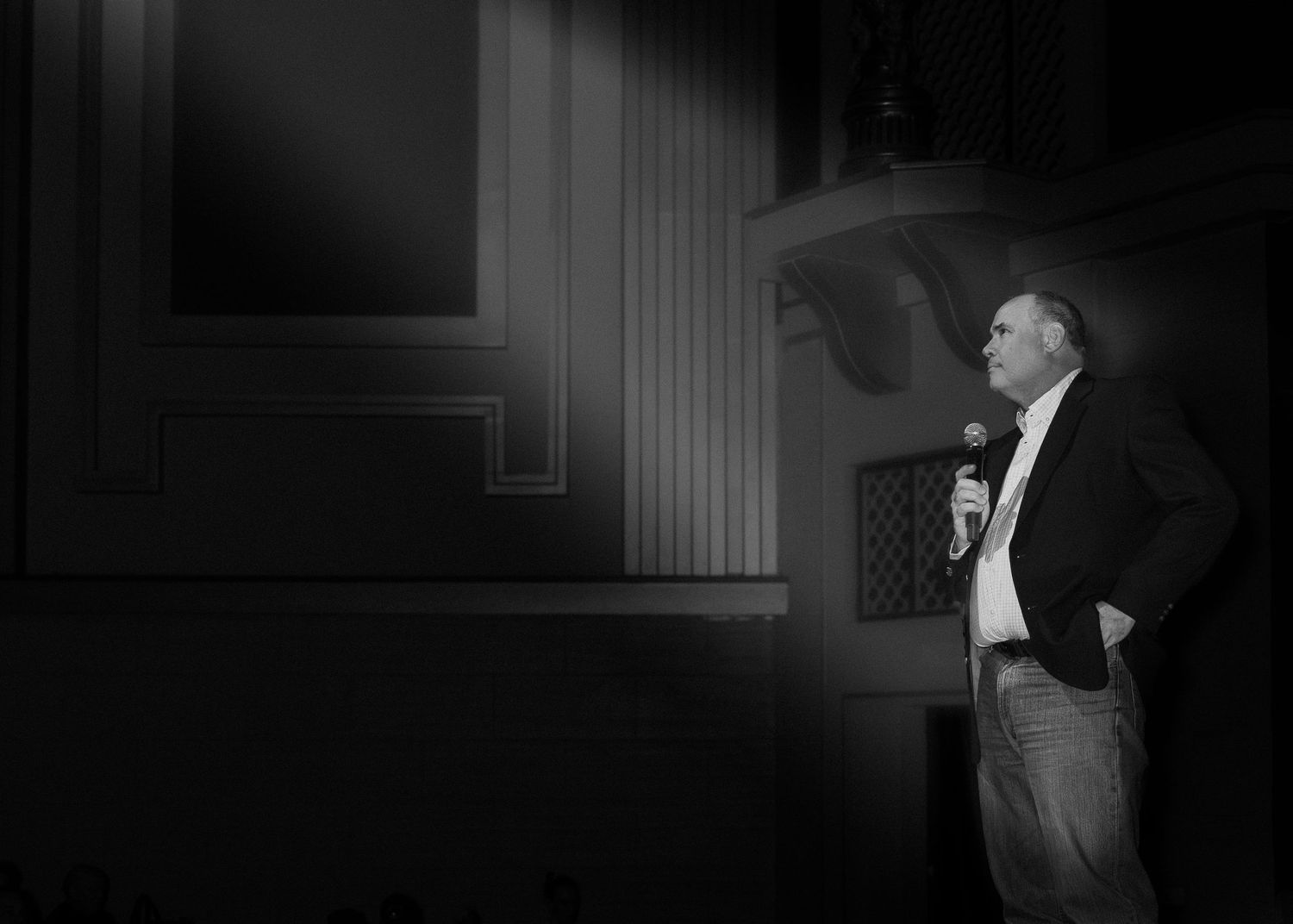 A dramatic black and white film noir sequence shows a person in silhouette against stark lighting and shadows.