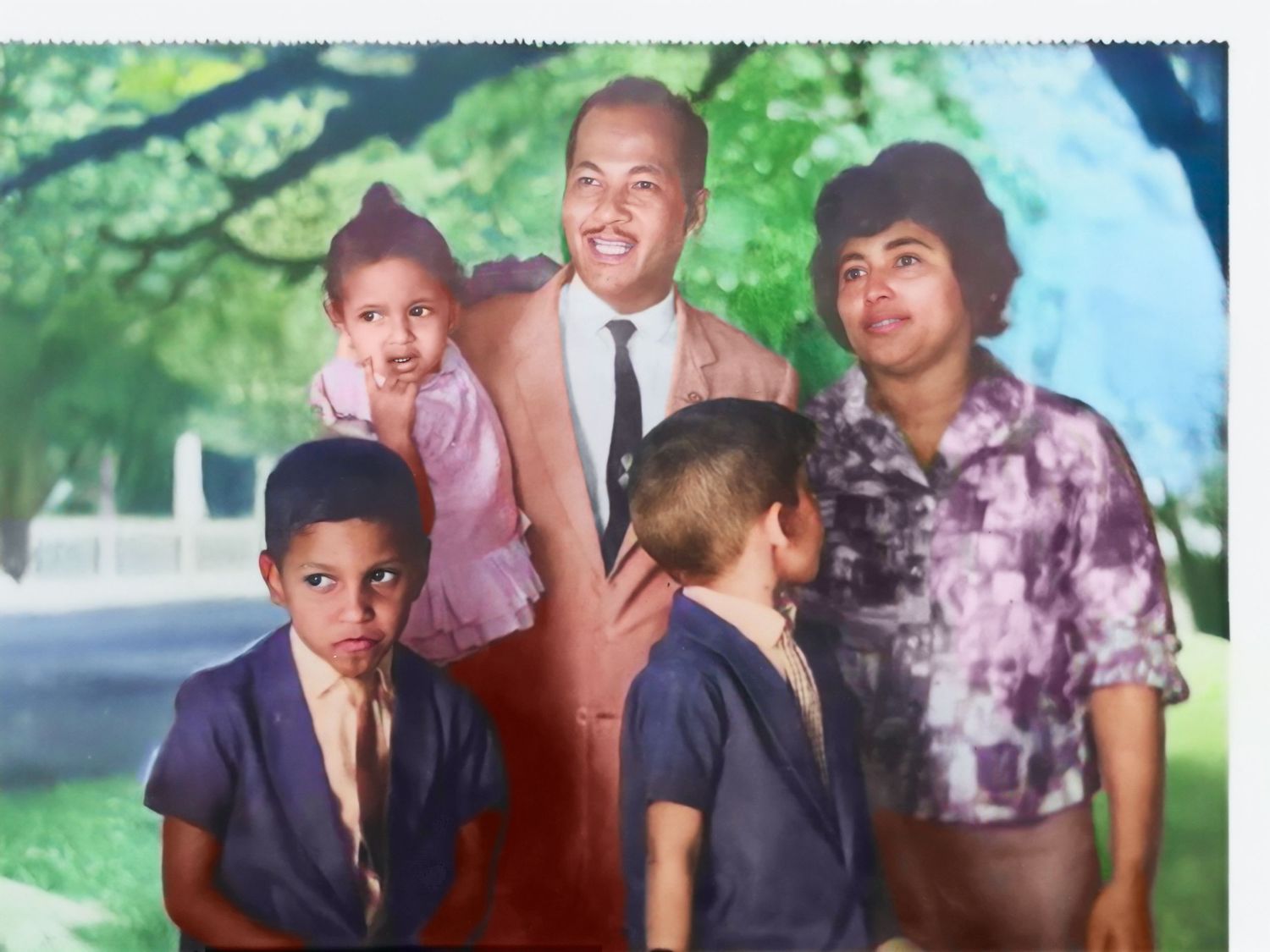 A fully restored Vintage family photograph outdoors under trees on a sunny day.