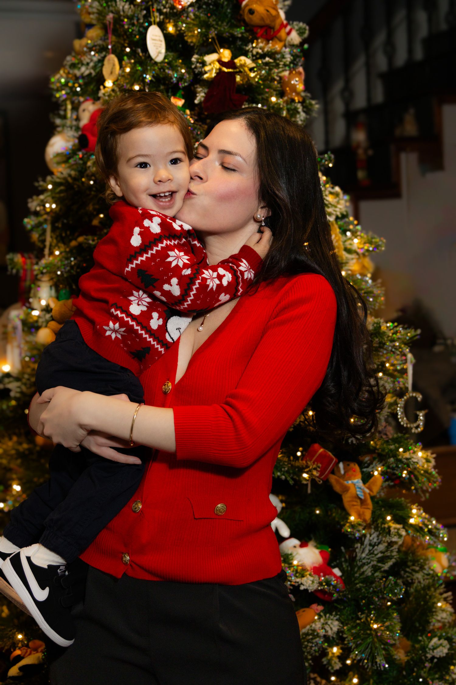 A heartwarming holiday scene with festive red sweaters and a decorated Christmas tree glowing in the background.