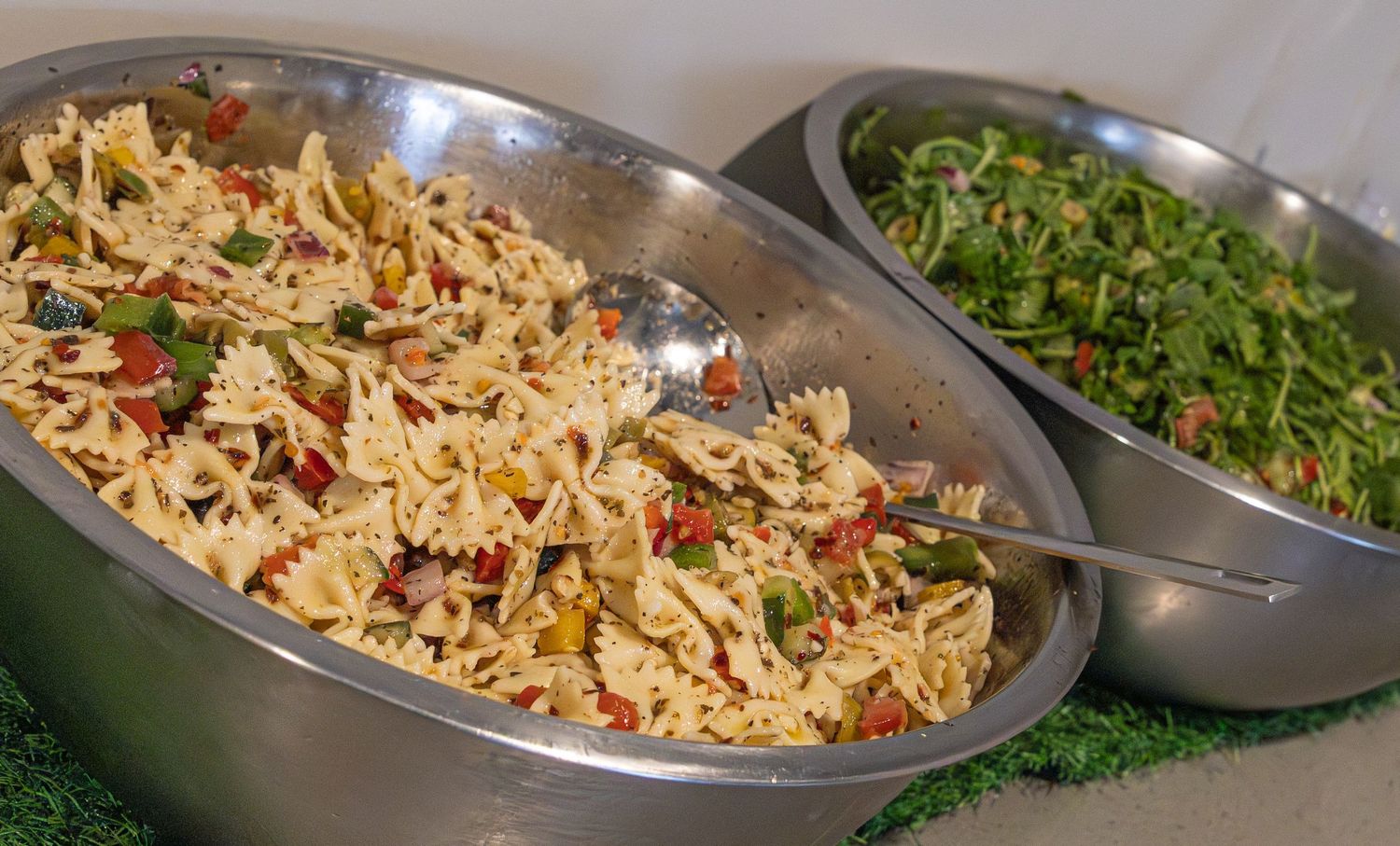 A sequence of cooking steps showing the preparation of a colorful rice and vegetable stir-fry dish in metal pans.