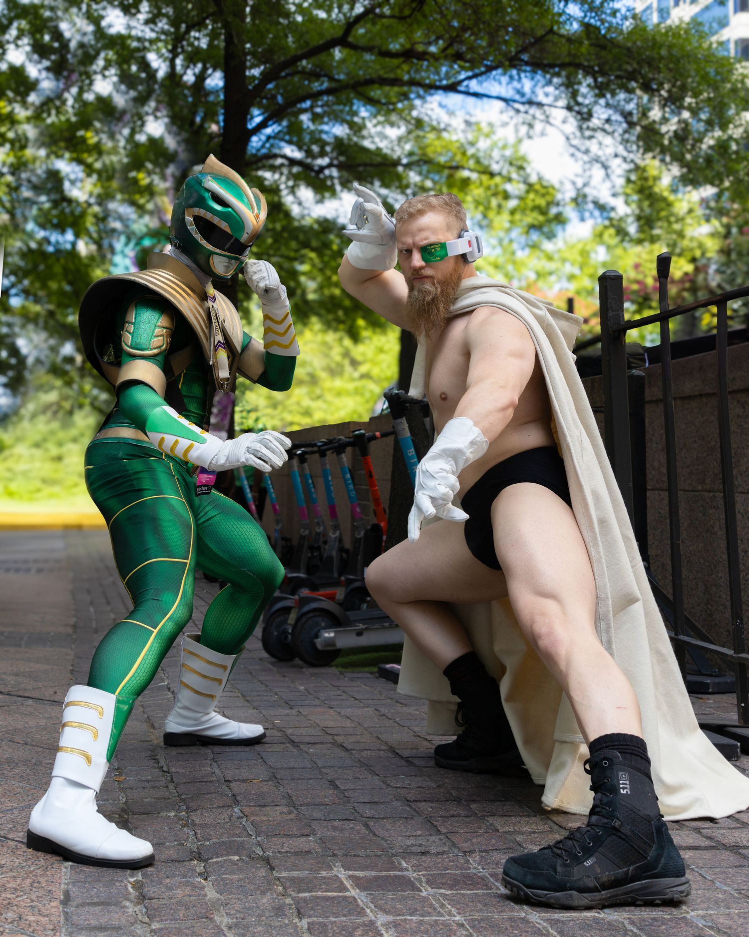 A series of five photos showing costumed figures in green and white outfits posing together on brick pavement.