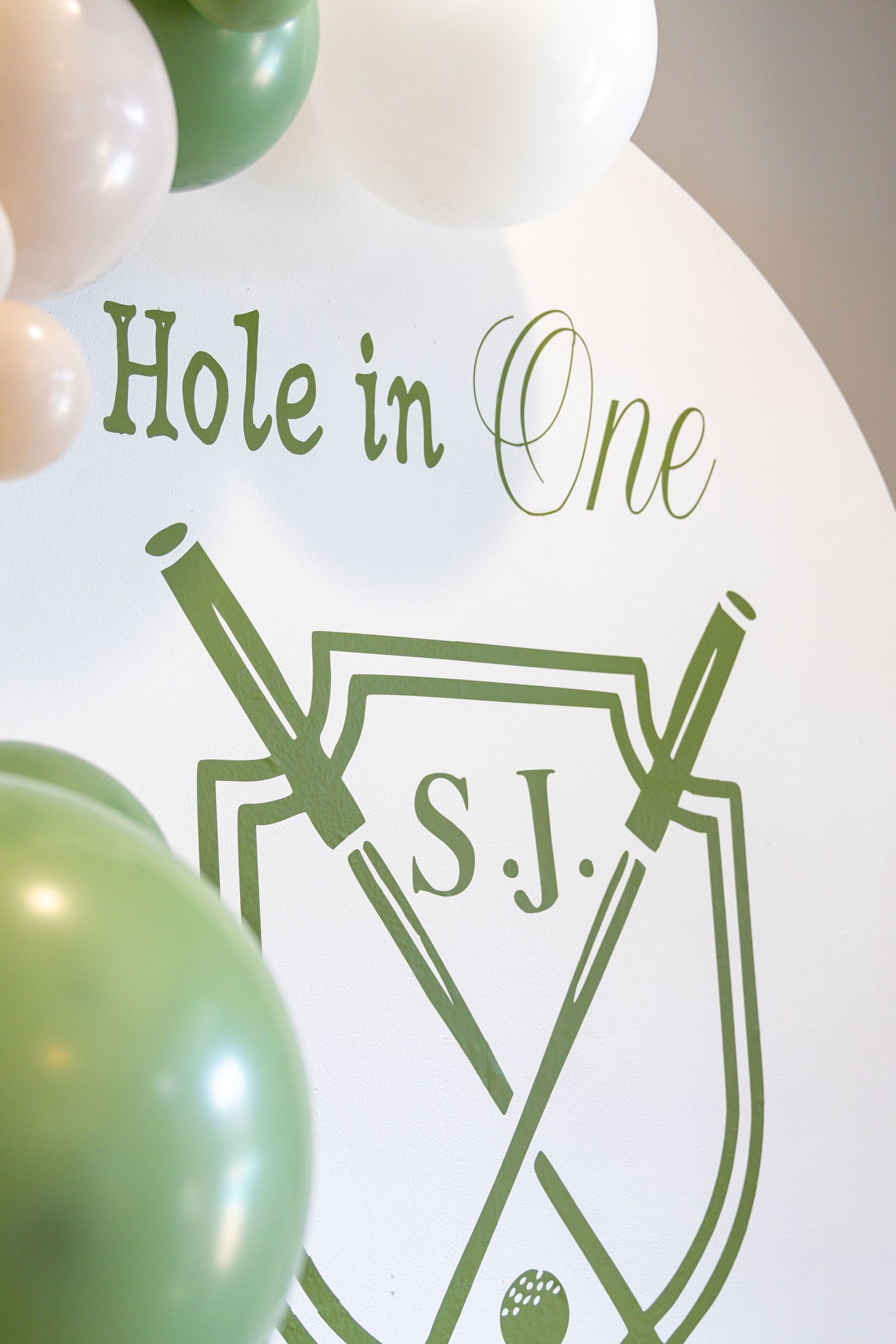 Green and white balloons with text decorations create a festive party atmosphere.
