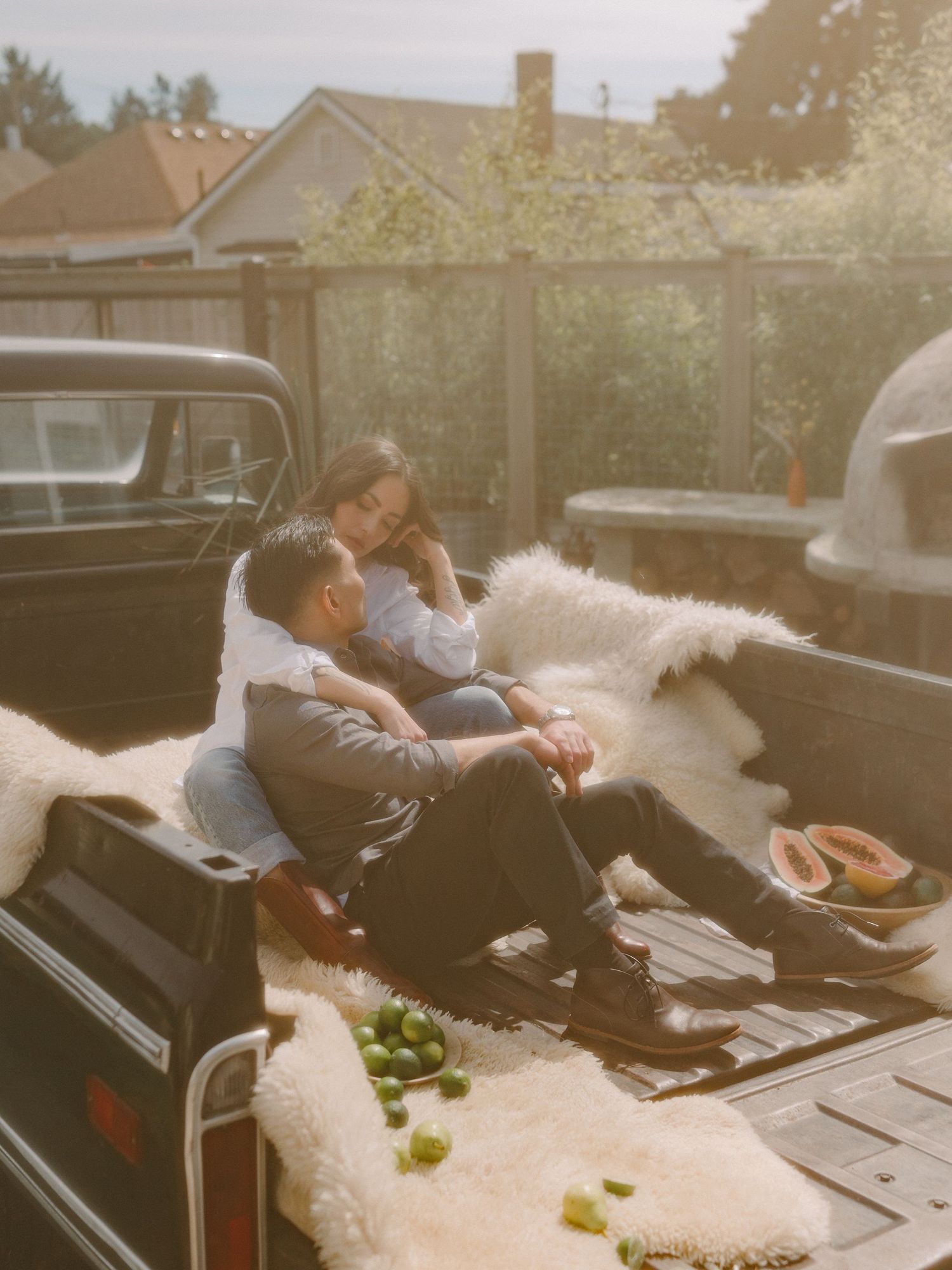 A couple lounging in the back of a vintage pickup truck with scattered limes.