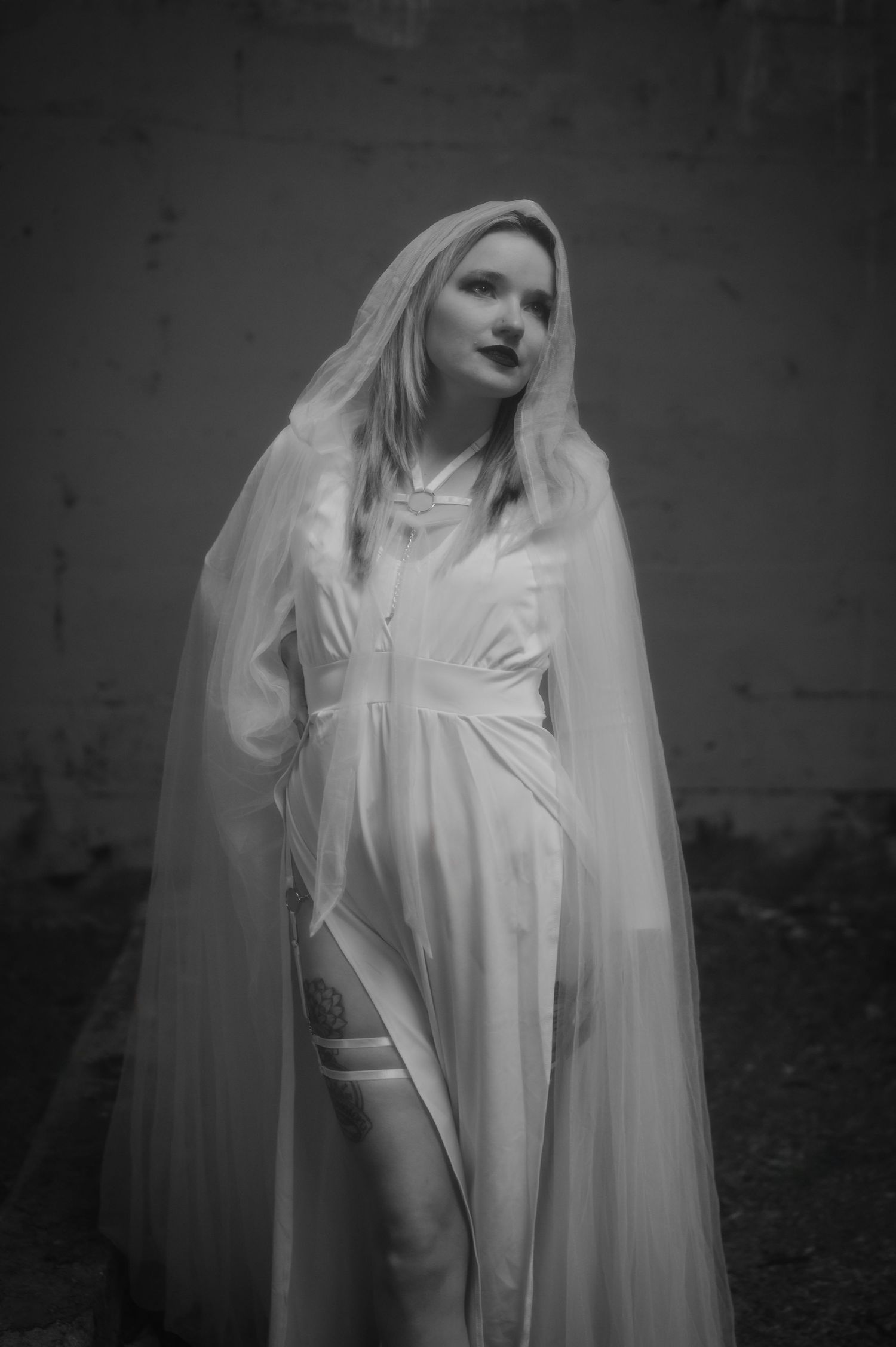 A haunting series of black and white photos showing an ethereal figure in flowing white fabric and veil against a dark background.