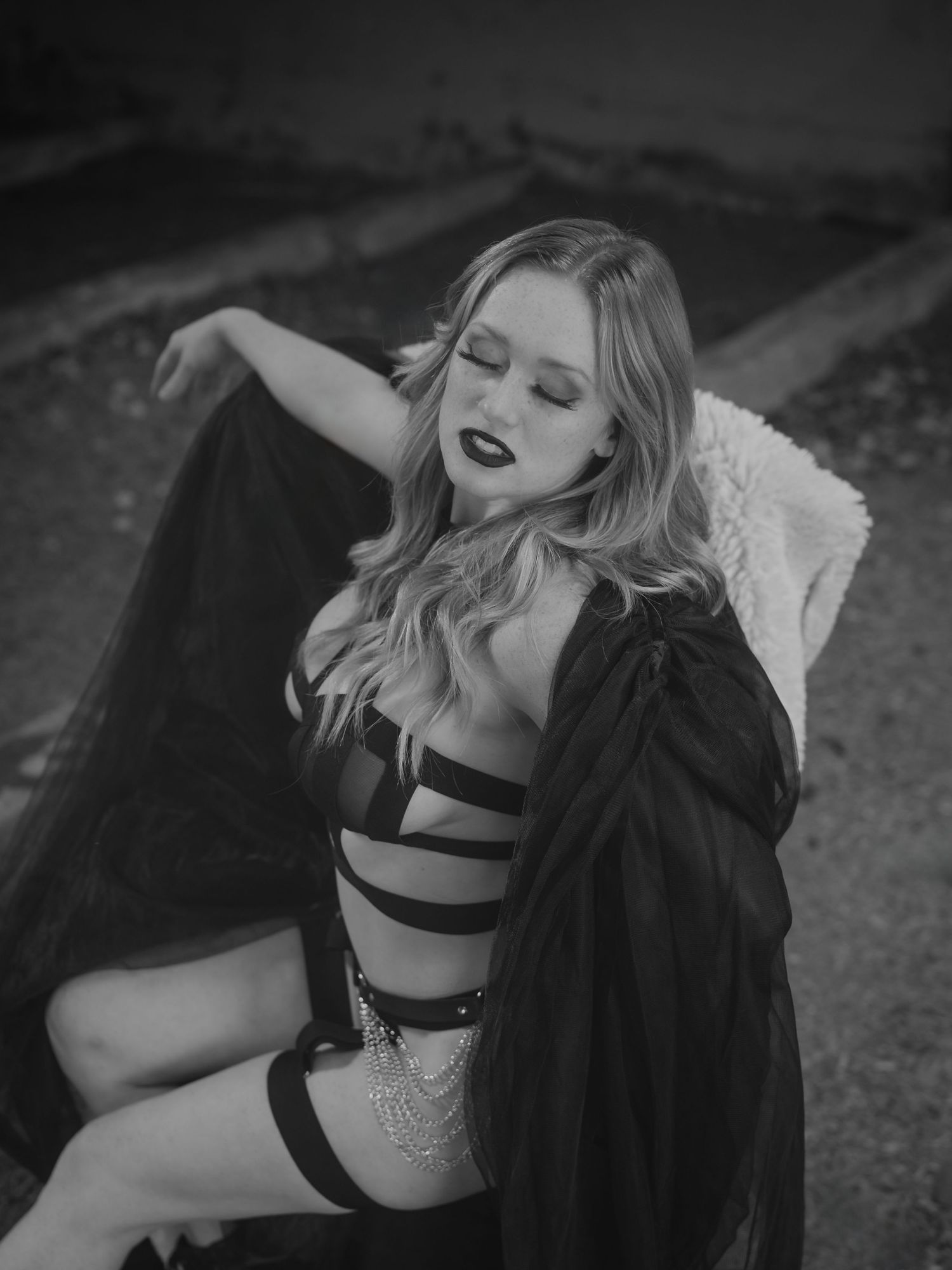Black and white dramatic portrait series showing expressive poses in contrasting lingerie and dark fabric.
