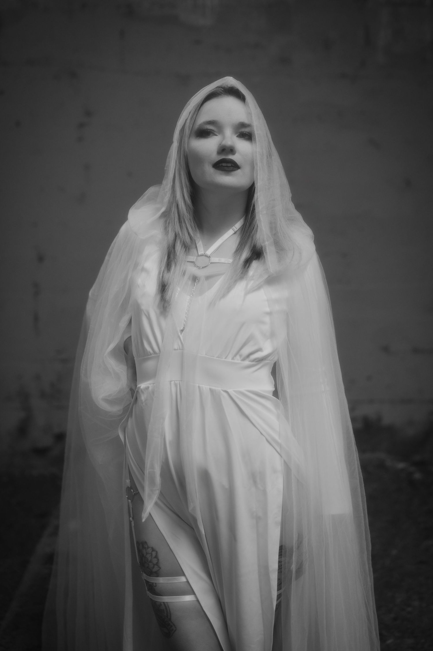 A dramatic black and white photo series shows a ghostly figure in white flowing fabric and veil against a dark background.