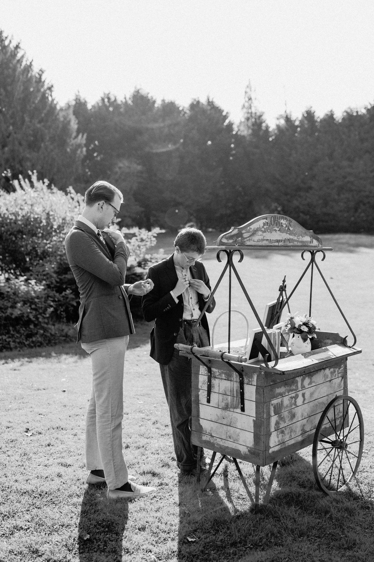 A vintage black and white photo of people at an old-fashioned ice cream cart.