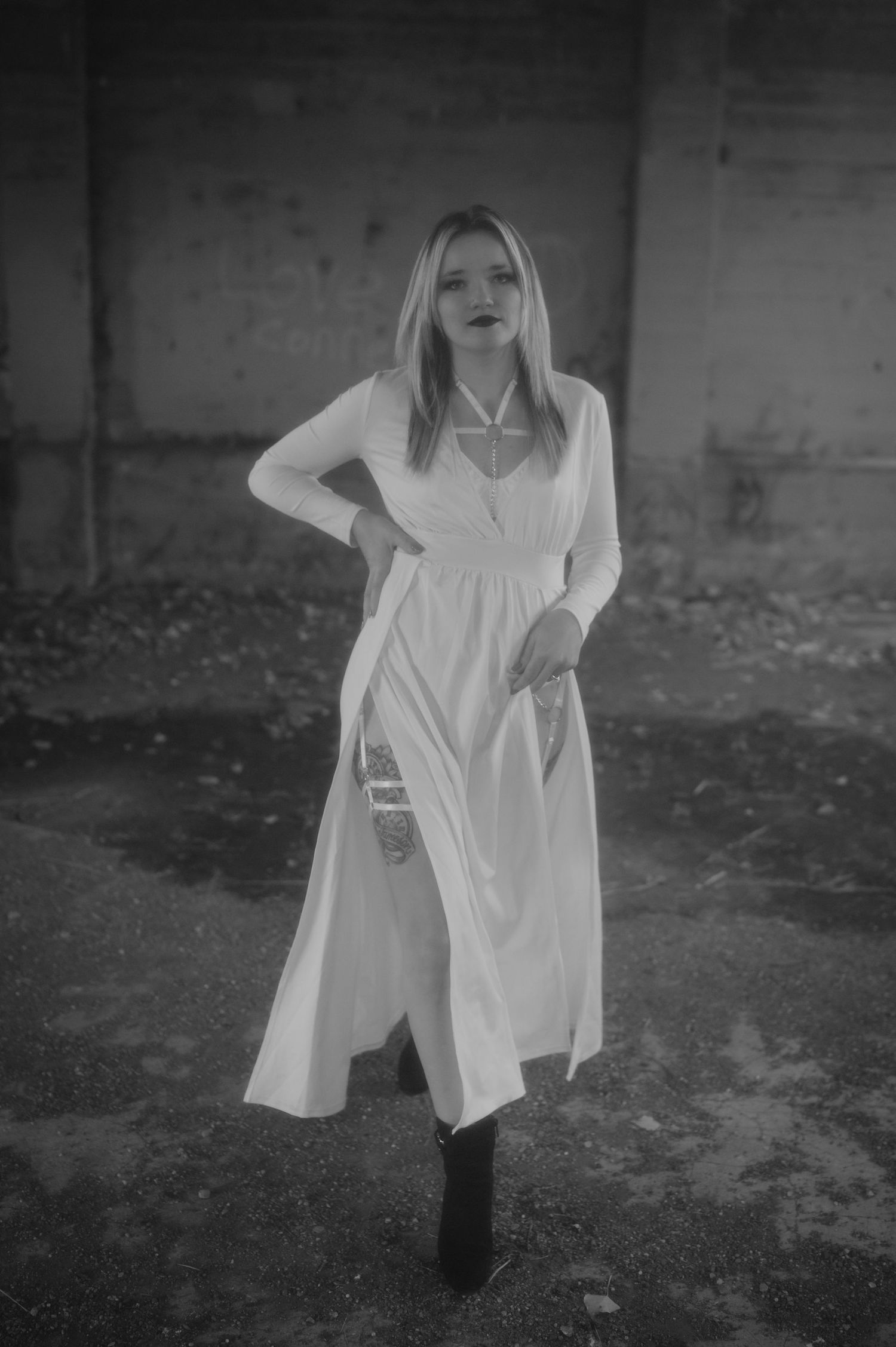 A series of black and white images showing a person in a flowing white dress moving through a moody outdoor setting.