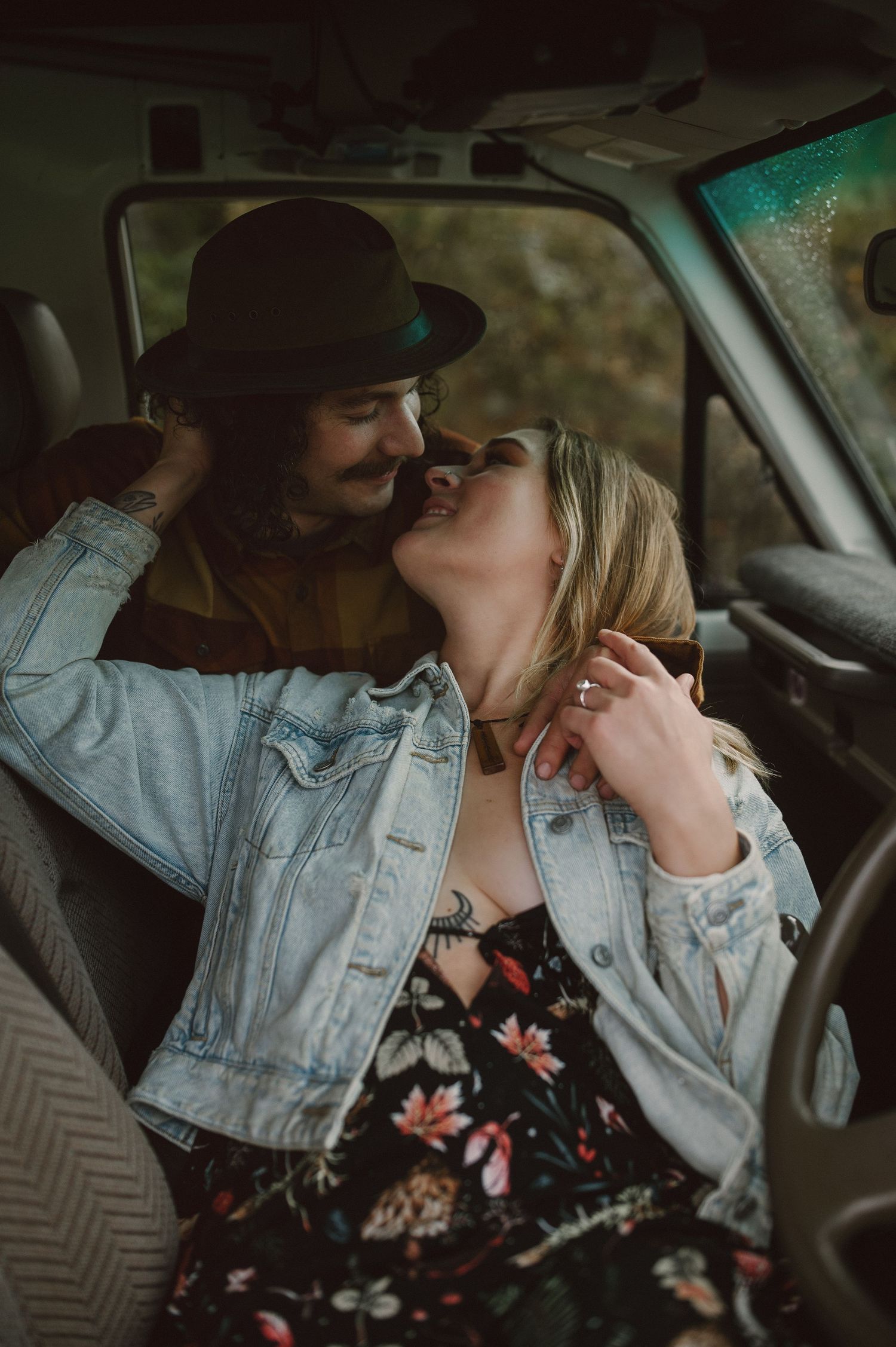 A couple shares an intimate moment inside a vintage vehicle.