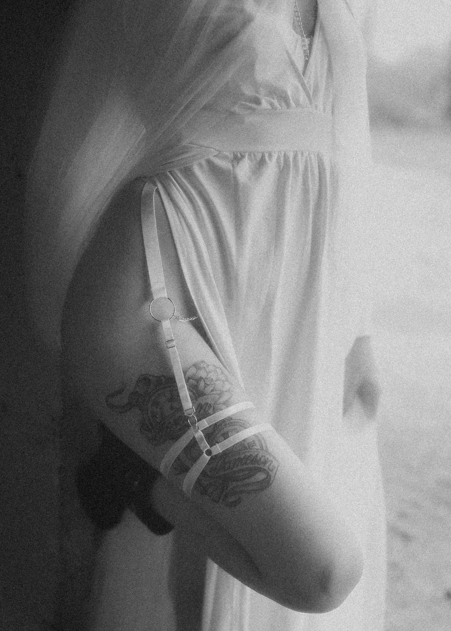 A series of blurry black and white photographs showing close-up details of a light colored garment with flowing fabric.