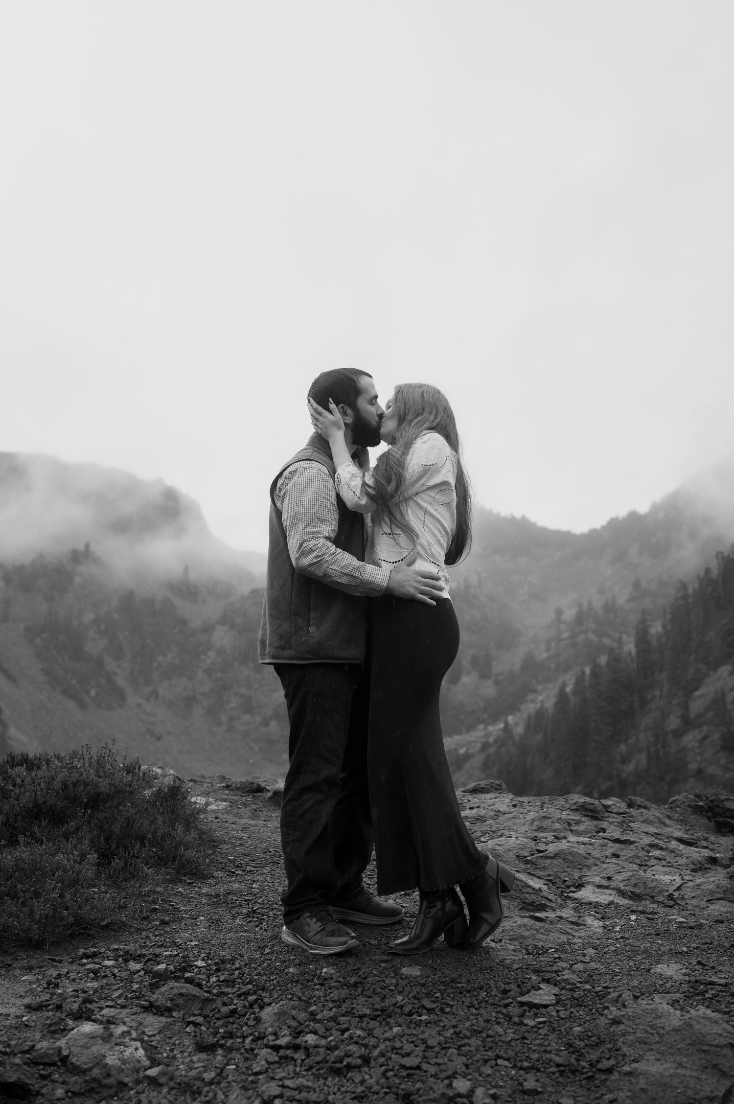 A series of vintage black and white photographs showing a couple embracing on a misty mountain landscape.