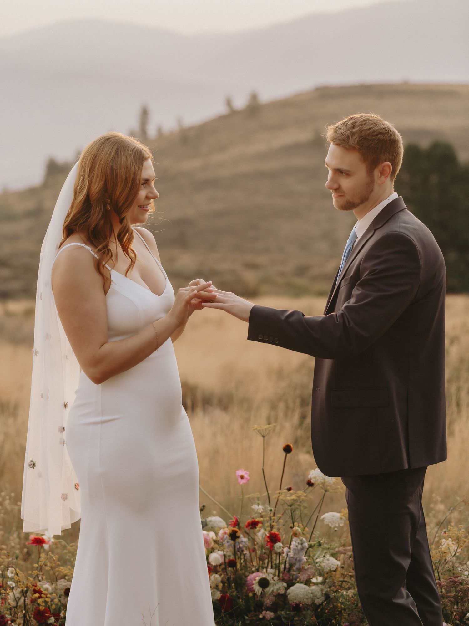 A couple exchanges rings during an intimate outdoor mountain ceremony.