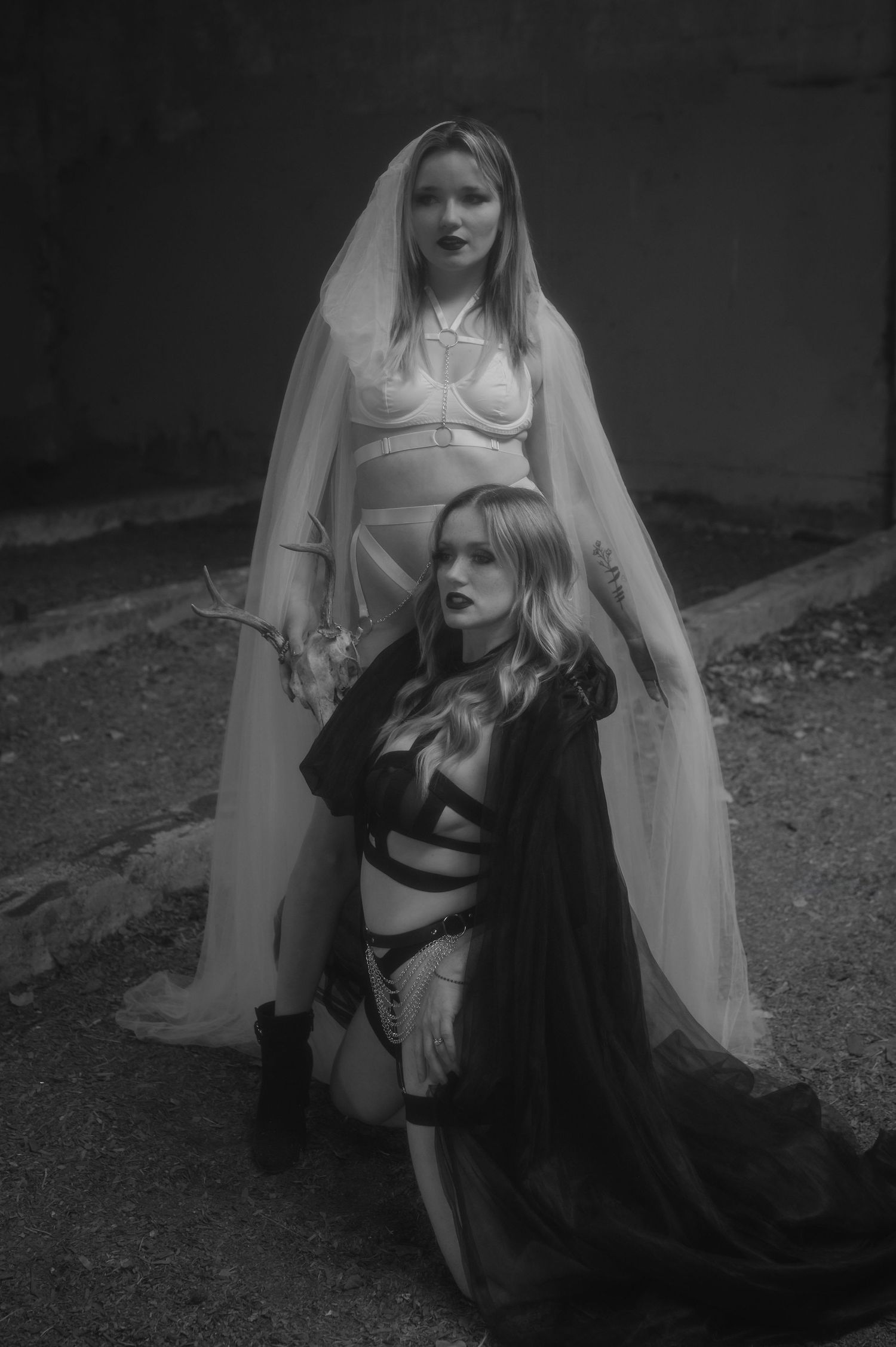 Black and white photo series showing ethereal figures in long flowing white veils and dark dresses in a gothic setting.