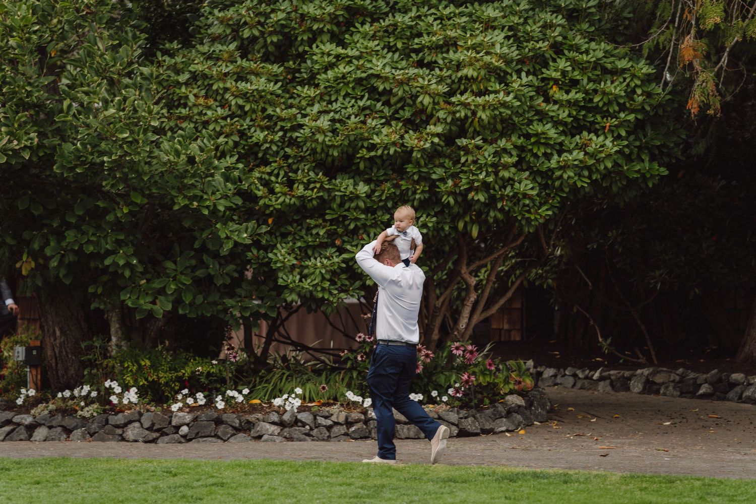 Wedding photographer captures couple in a romantic outdoor garden setting with lush greenery and natural light.