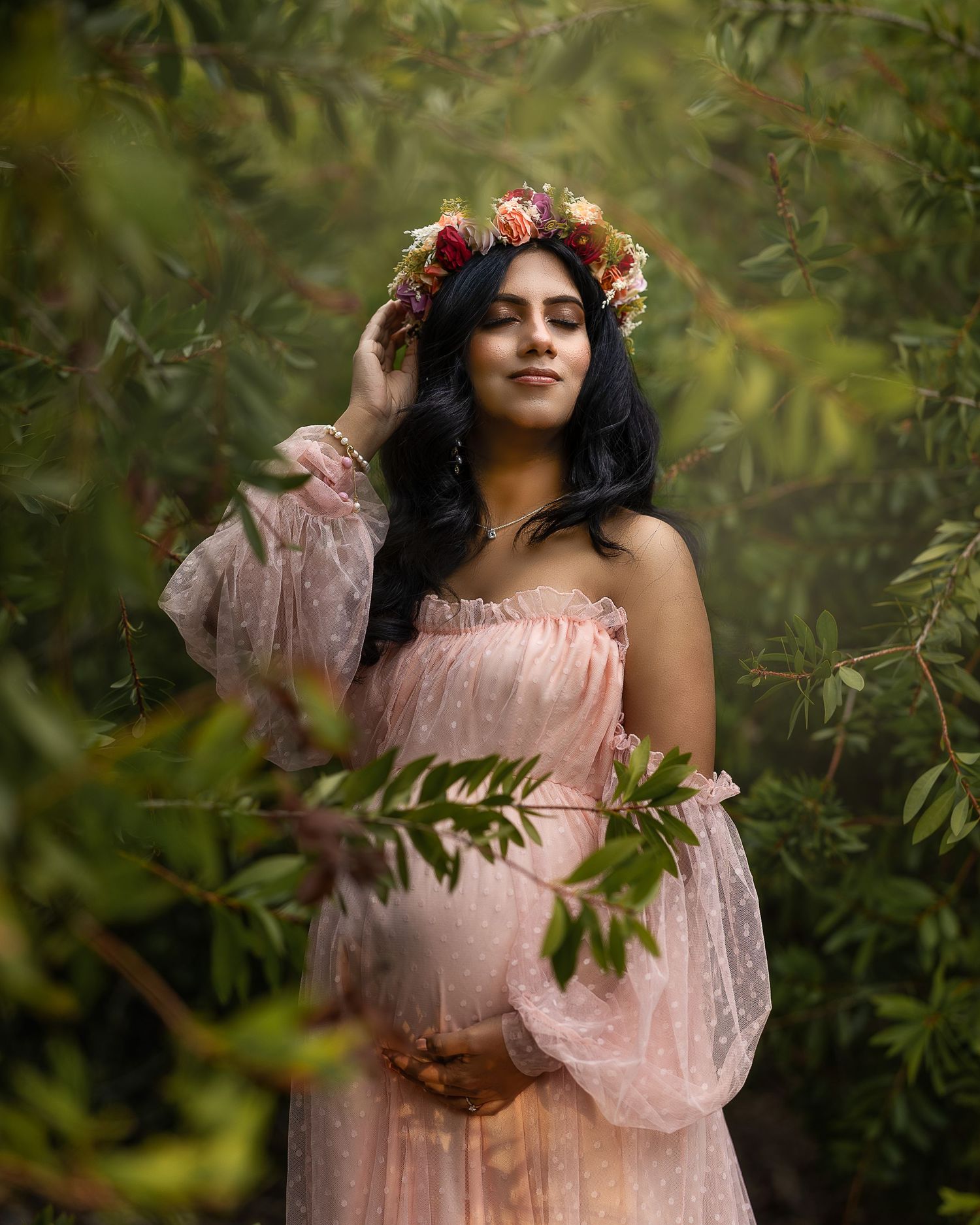 A person in a pink vintage-style dress poses gracefully in a lush garden setting with natural lighting and floral accents.