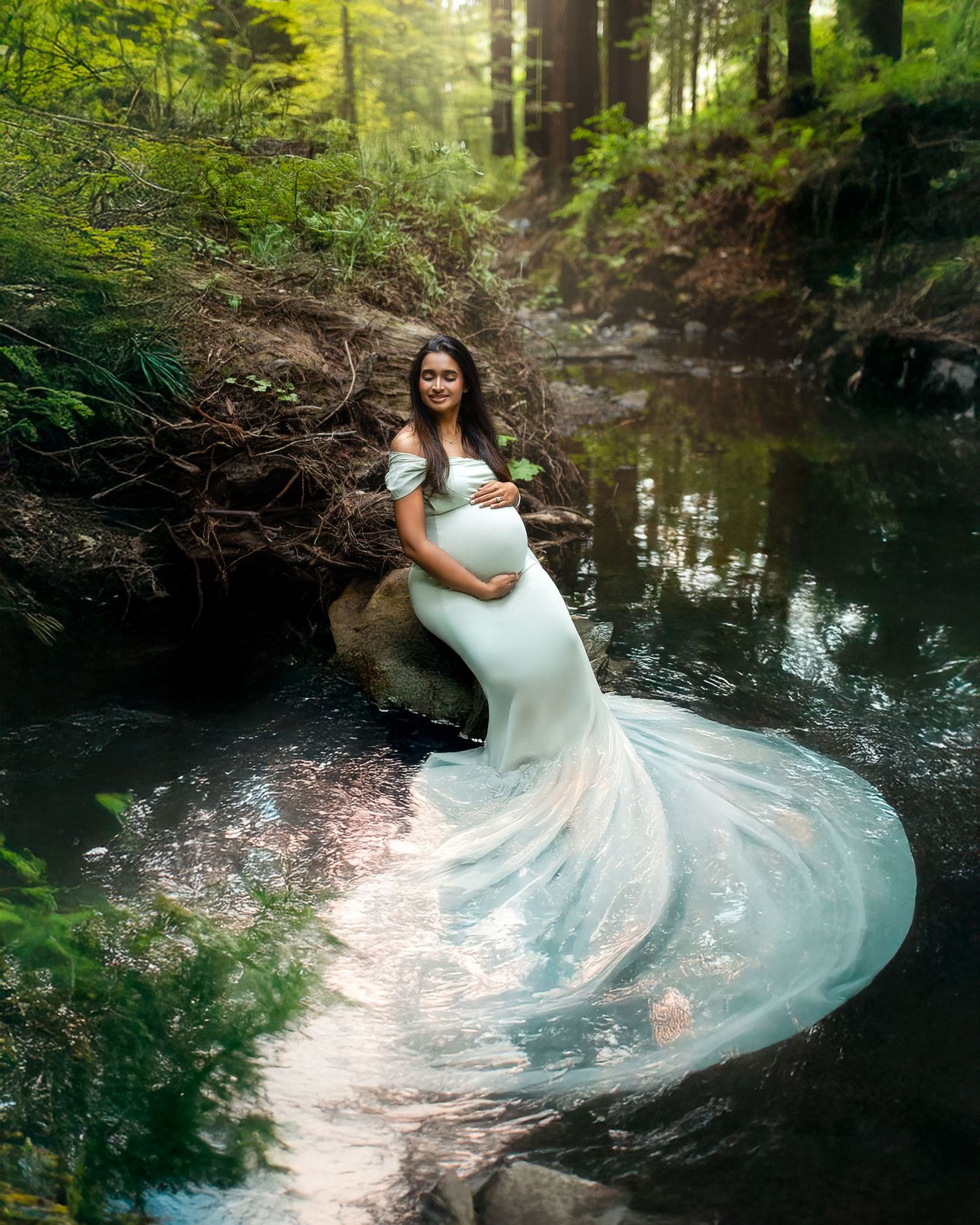 A flowing white dress creates a graceful swirl effect over a tranquil forest stream in a romantic outdoor scene.