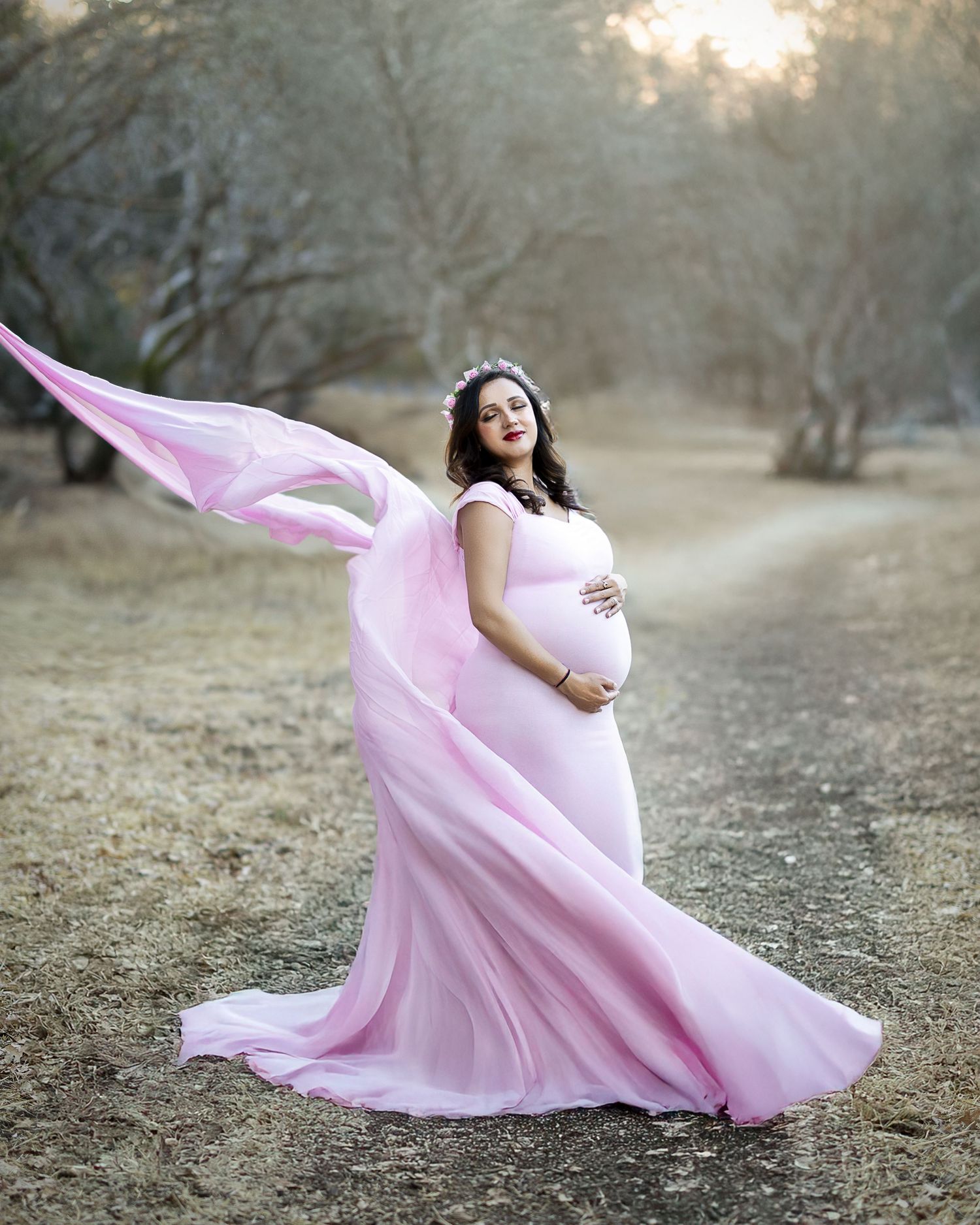 A flowing pink dress creates ethereal movement against a natural outdoor backdrop in a series of graceful poses.