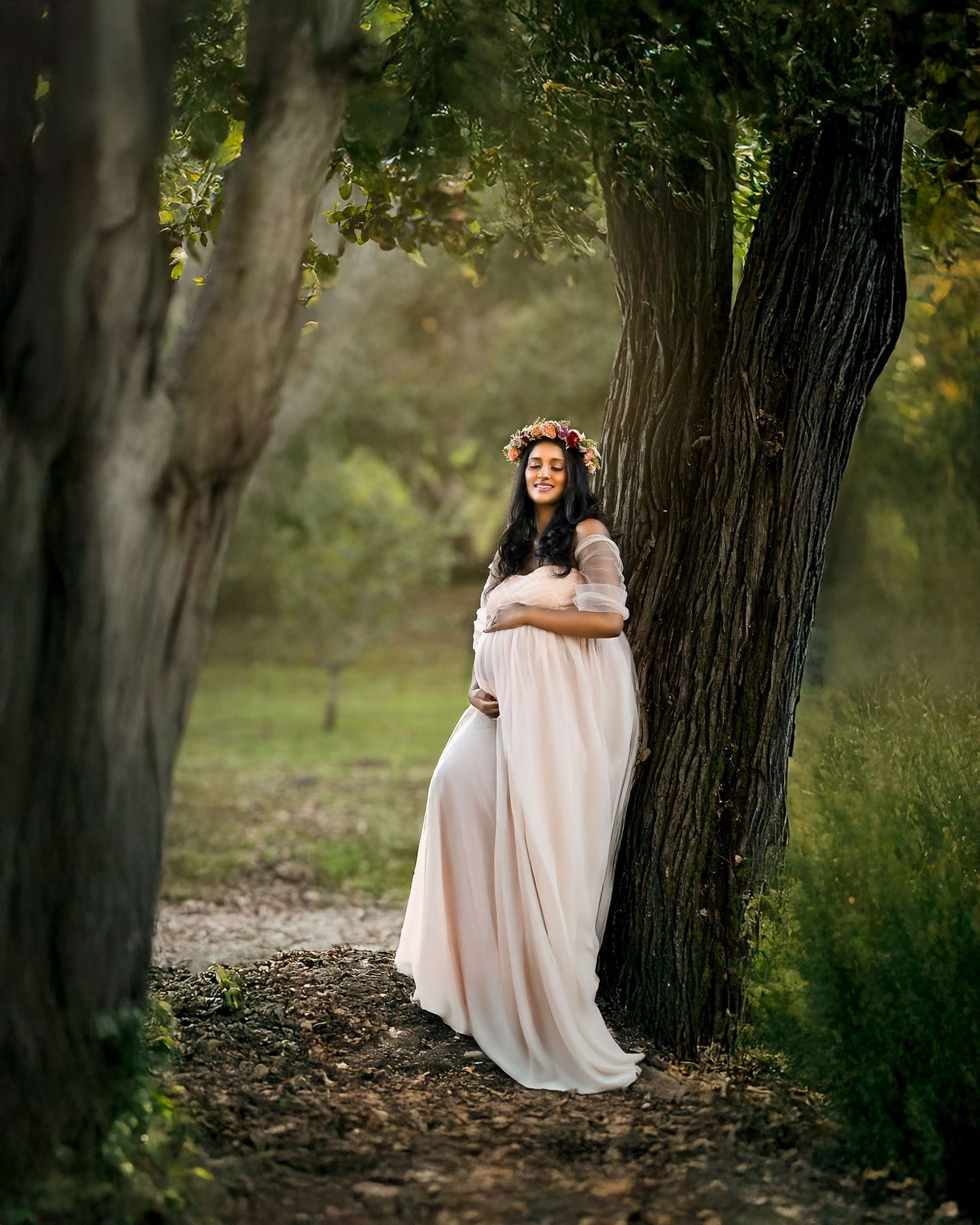 A dreamy outdoor portrait session in a wooded area with soft natural lighting and ethereal atmosphere.