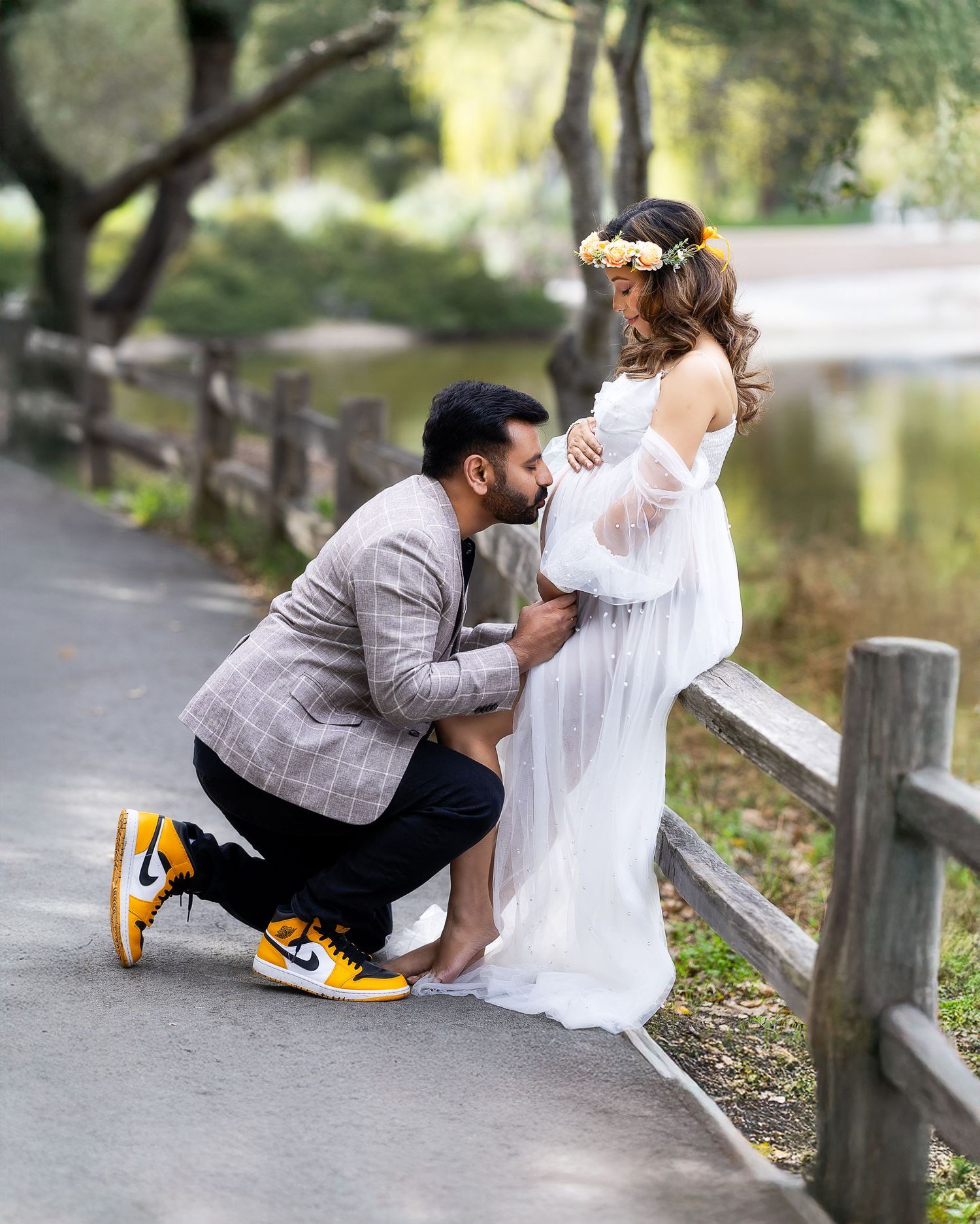 A couple in wedding attire sits together on a wooden fence by a lake in a romantic sequence of photos.