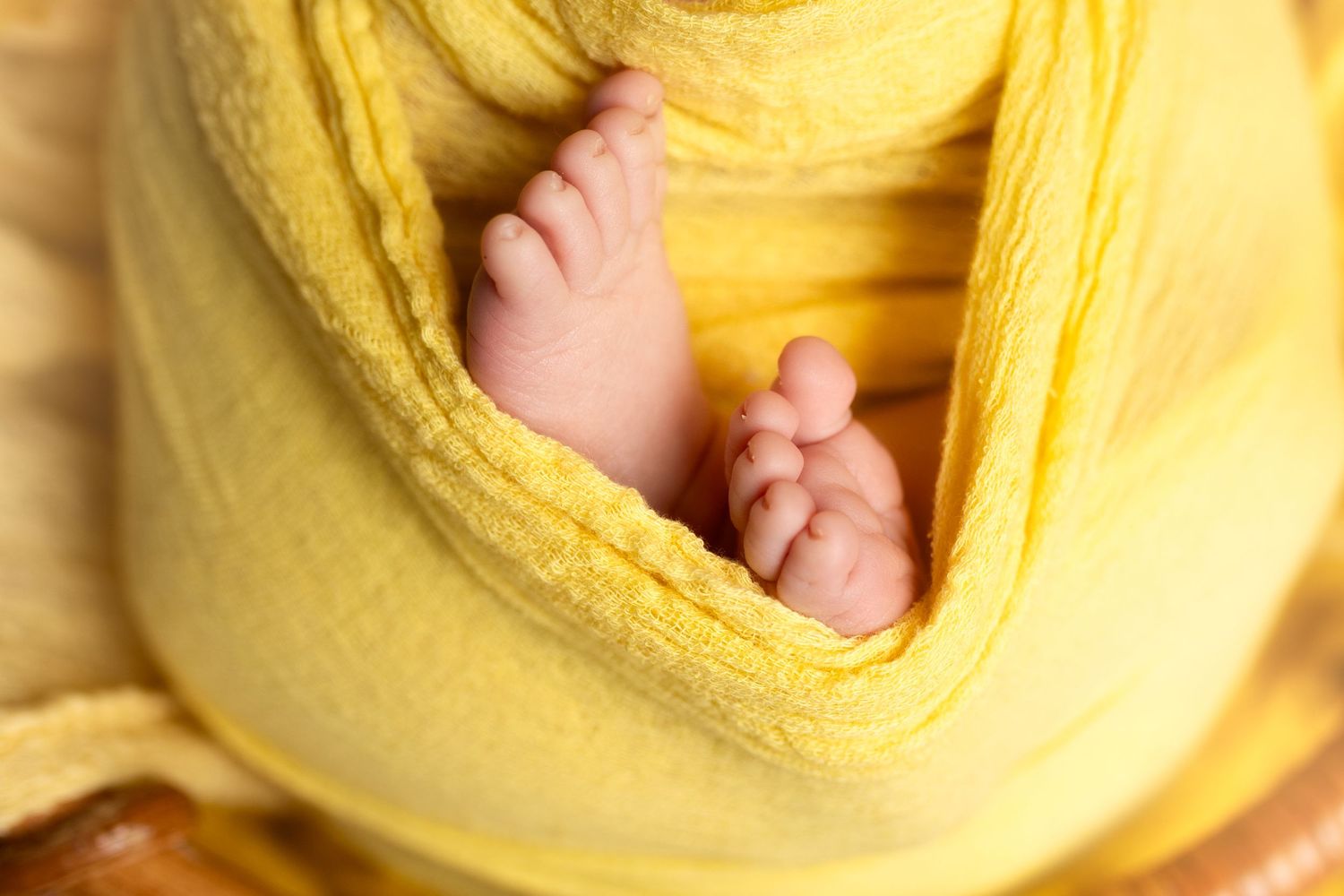 Close-up view of yellow knitted blanket with delicate lace patterns and soft textures.