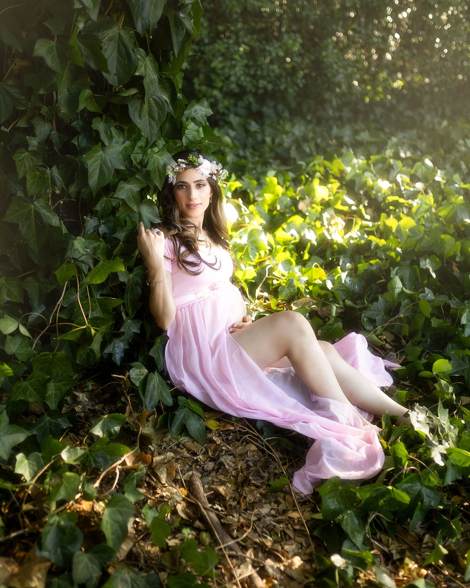 A series of artistic portraits showing a person in a pink dress laying among green foliage and yellow flowers in natural light.
