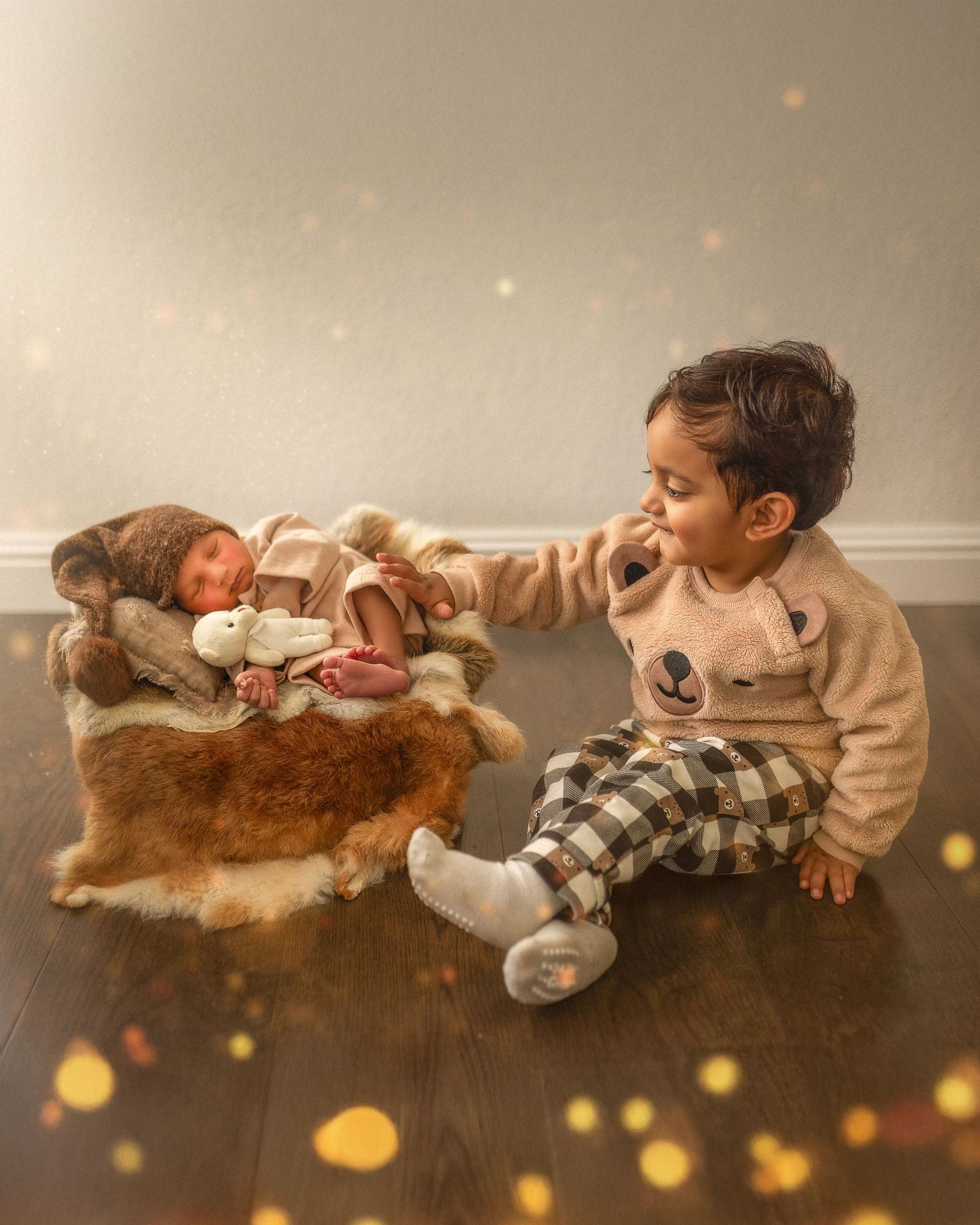 A baby sleeps peacefully on a plush brown fur rug with soft bokeh lights in the background.