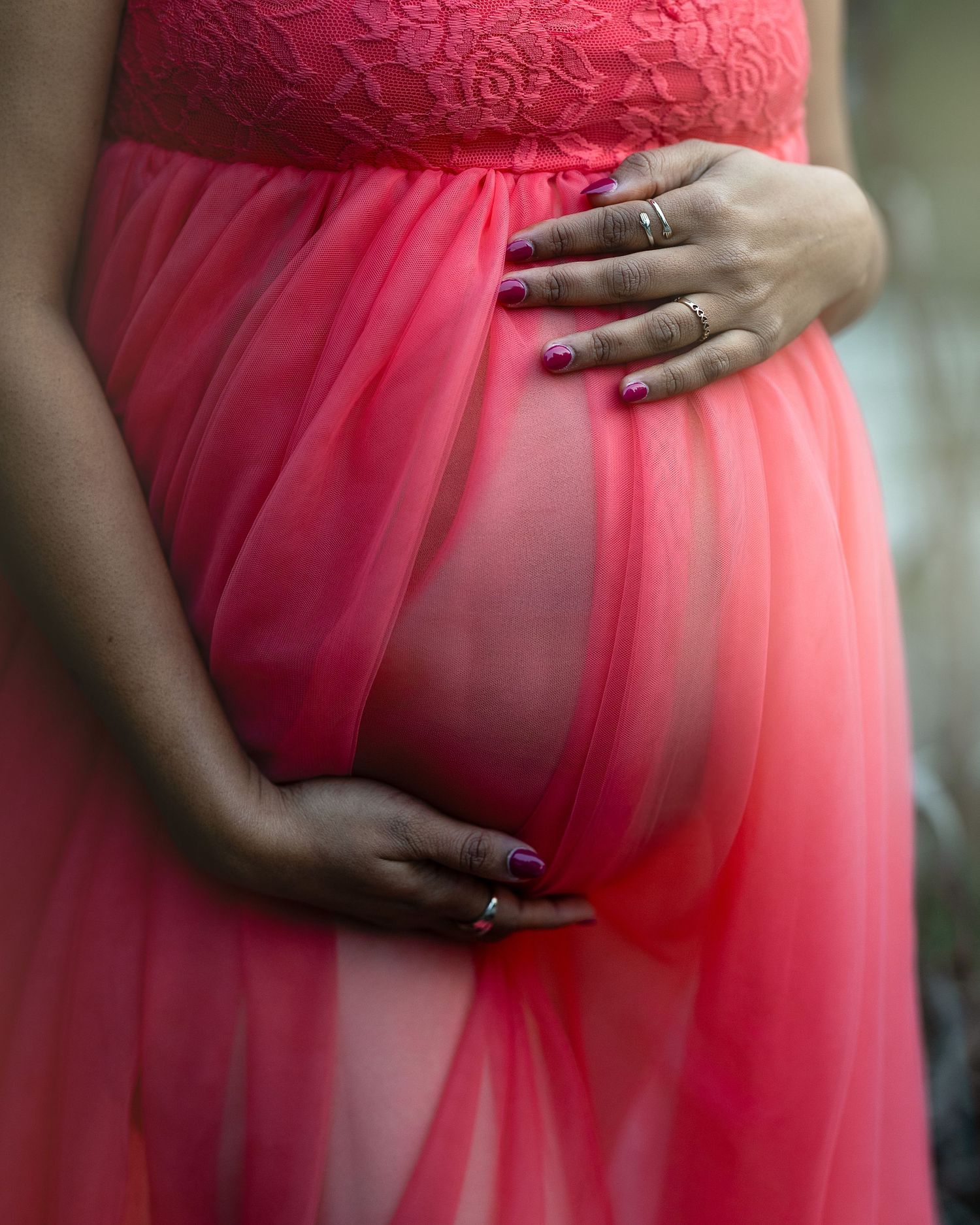 Close-up shots of a coral tulle maternity dress showing the fabric's delicate draping and texture.
