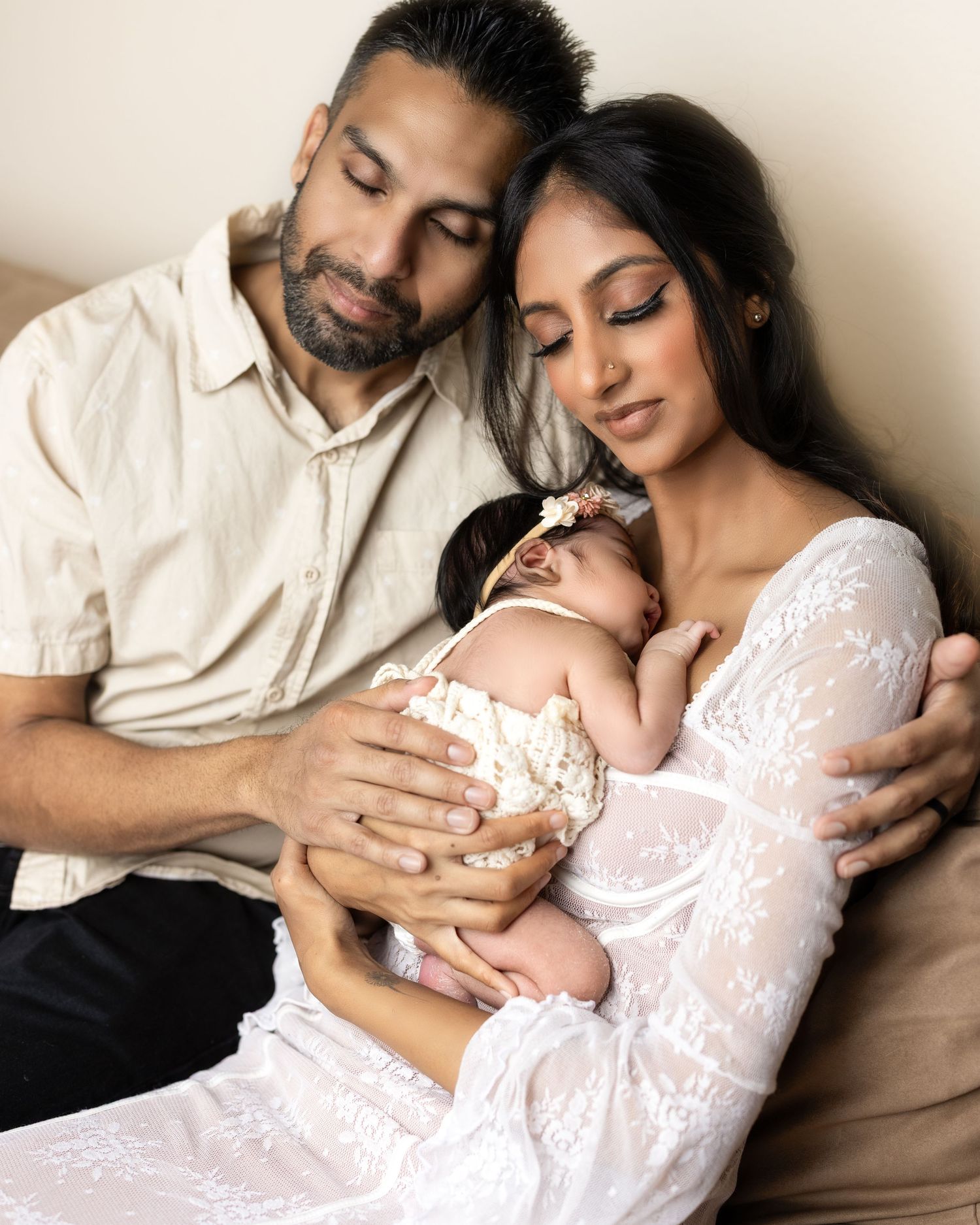 A tender family moment captured in a series of intimate poses with a newborn baby against a neutral backdrop.