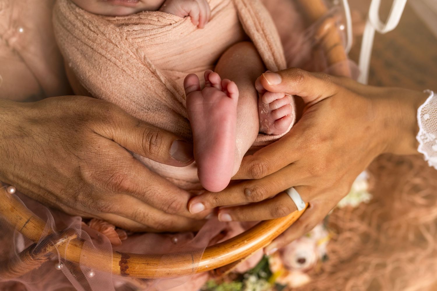 Close-up shot of hands preparing homemade dough for baking on a wooden surface.