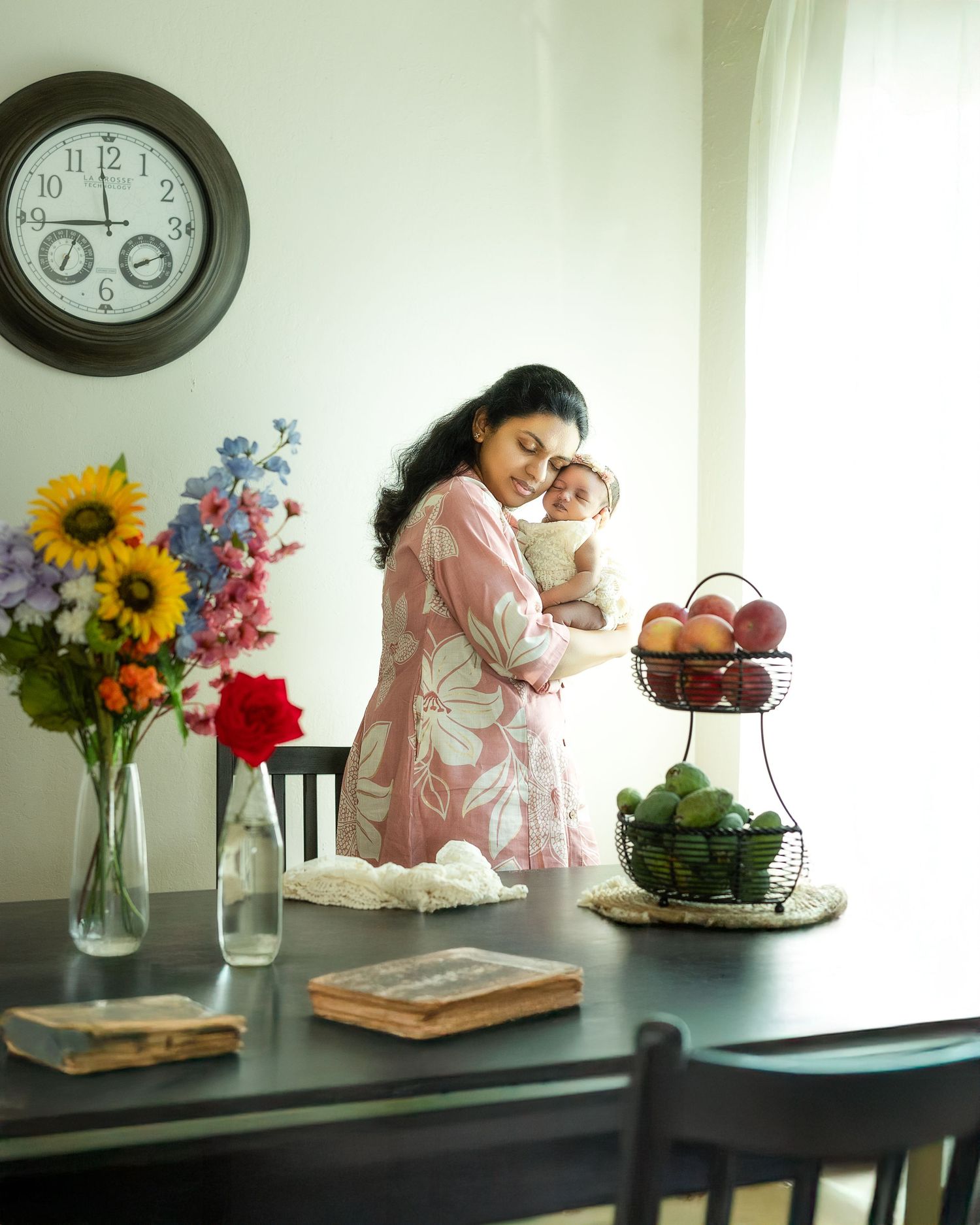 A series of still life photos showing flowers in vases, books, and decorative items arranged on a dark table beneath wall clocks.