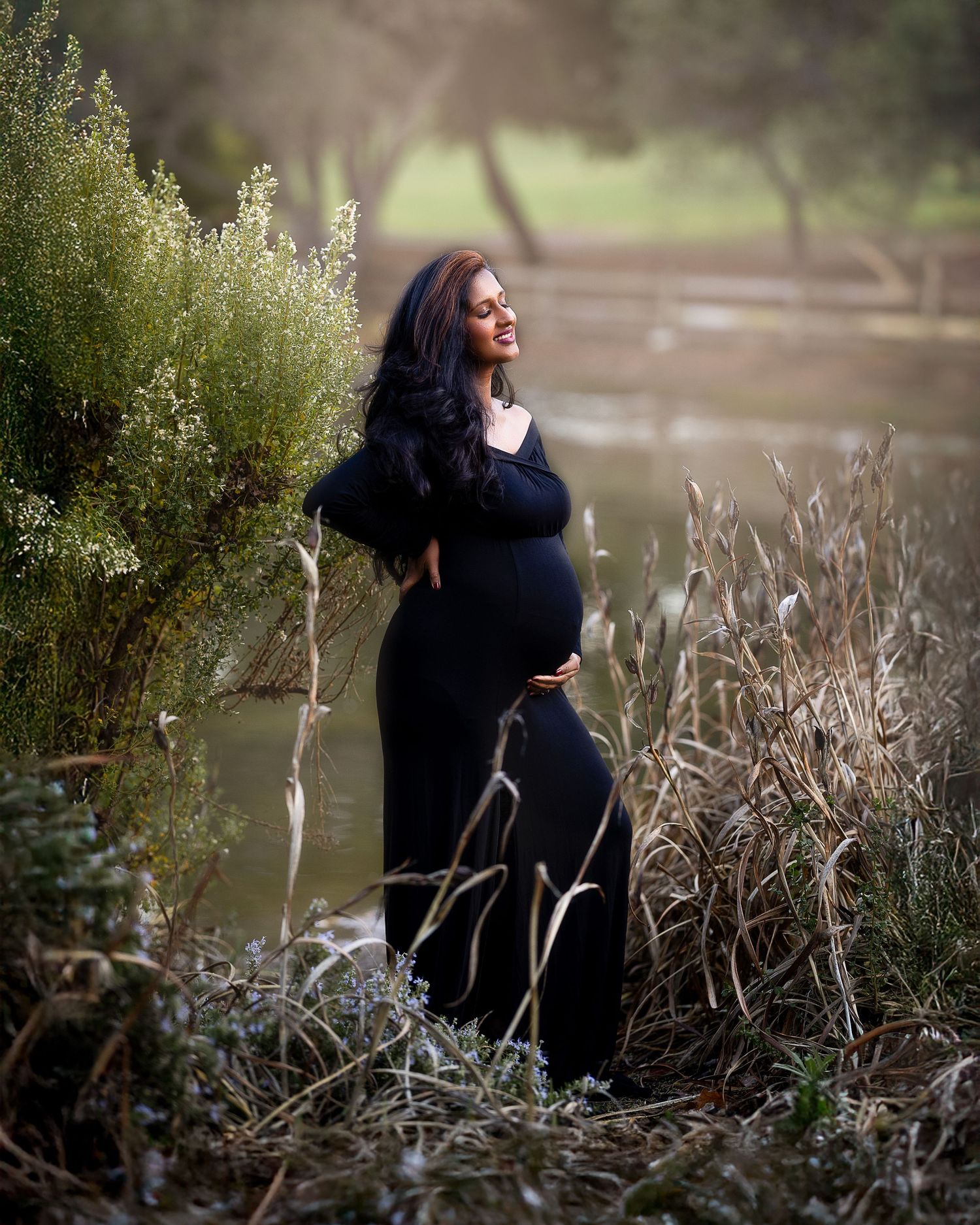 A series of artistic outdoor portraits showing a person in a black outfit posing among bare branches near a lake.