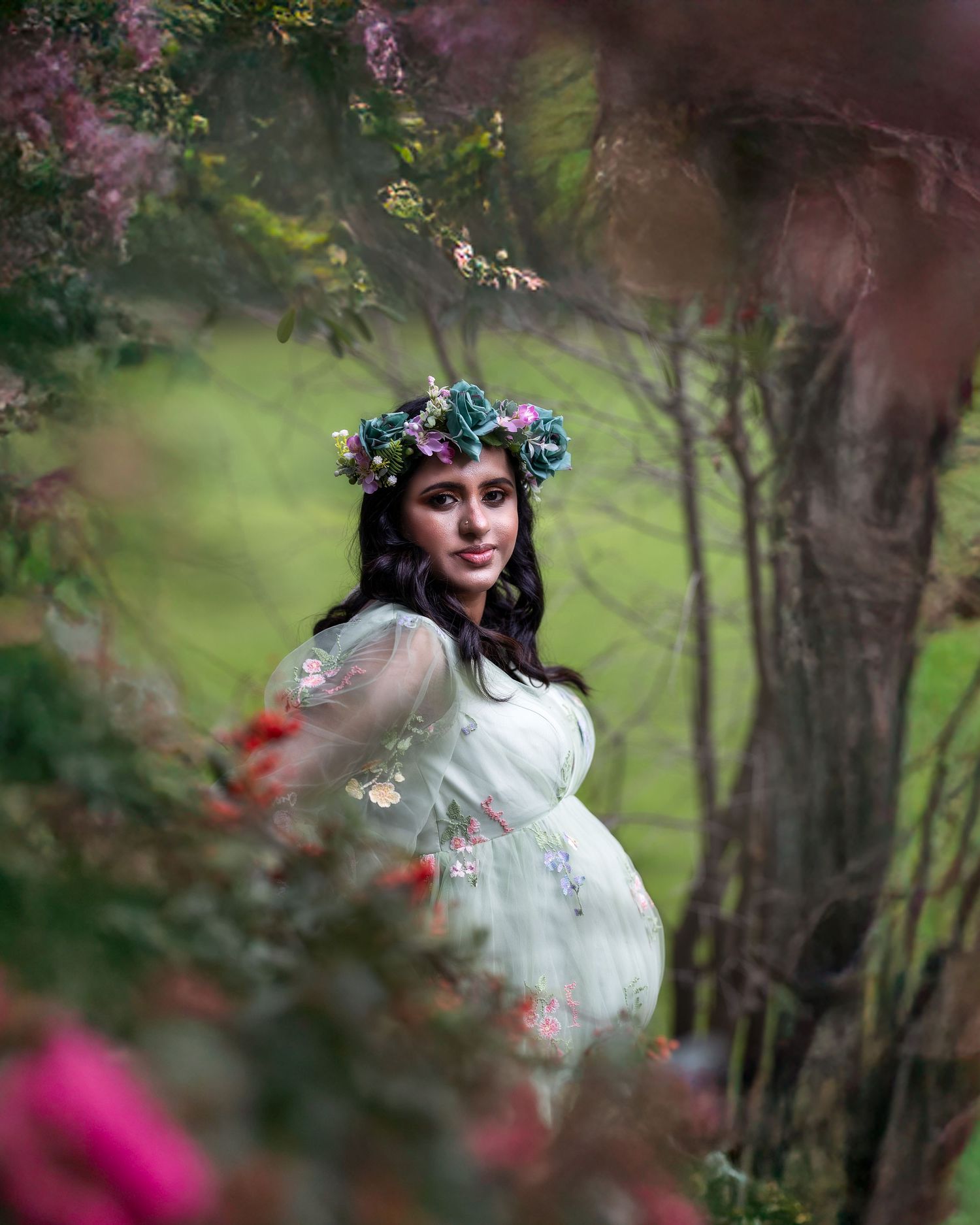 A dreamy portrait session in a garden setting with soft bokeh and flowering trees creating a romantic atmosphere.