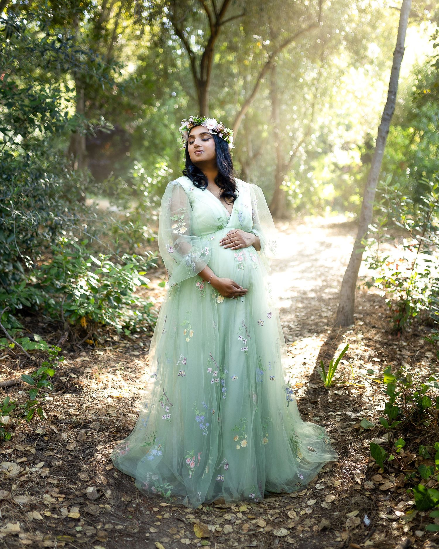 A dreamy forest scene with mint green tulle dresses catching ethereal sunlight filtering through the trees.