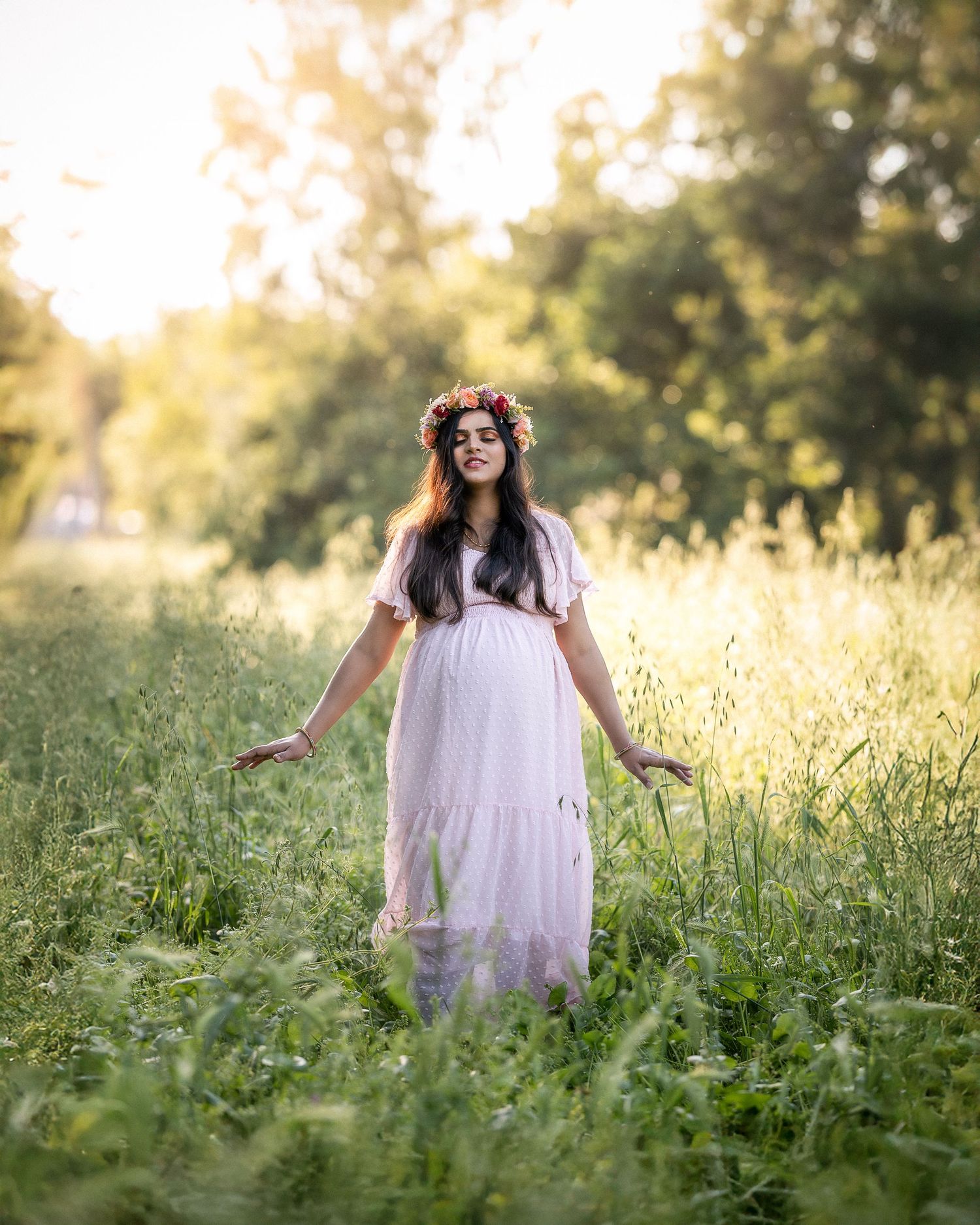 A dreamy summer scene shows someone in a white dress standing in a golden wildflower meadow at sunset.