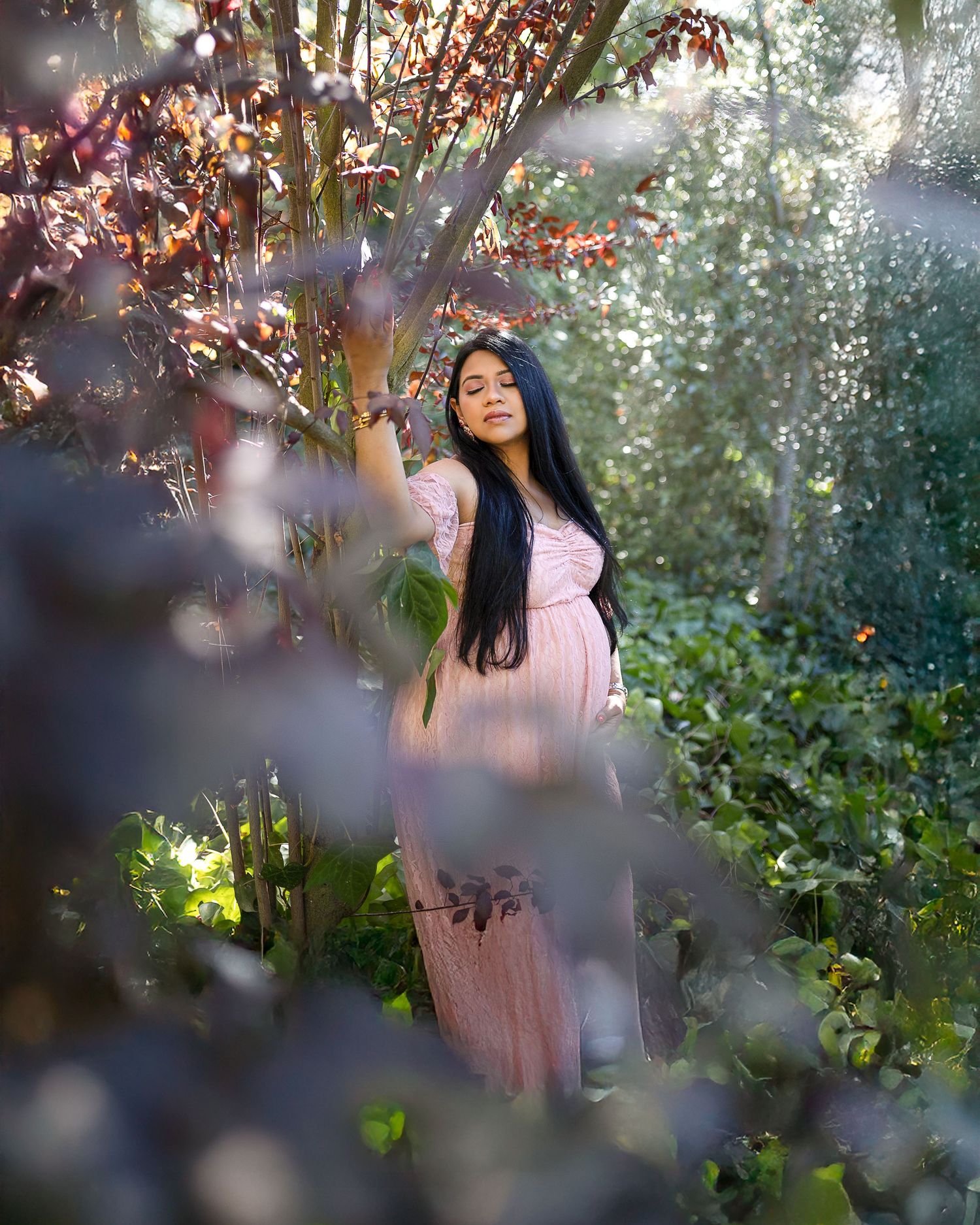 A dreamy portrait series in a garden setting with soft natural lighting and pink floral elements creates an ethereal mood.