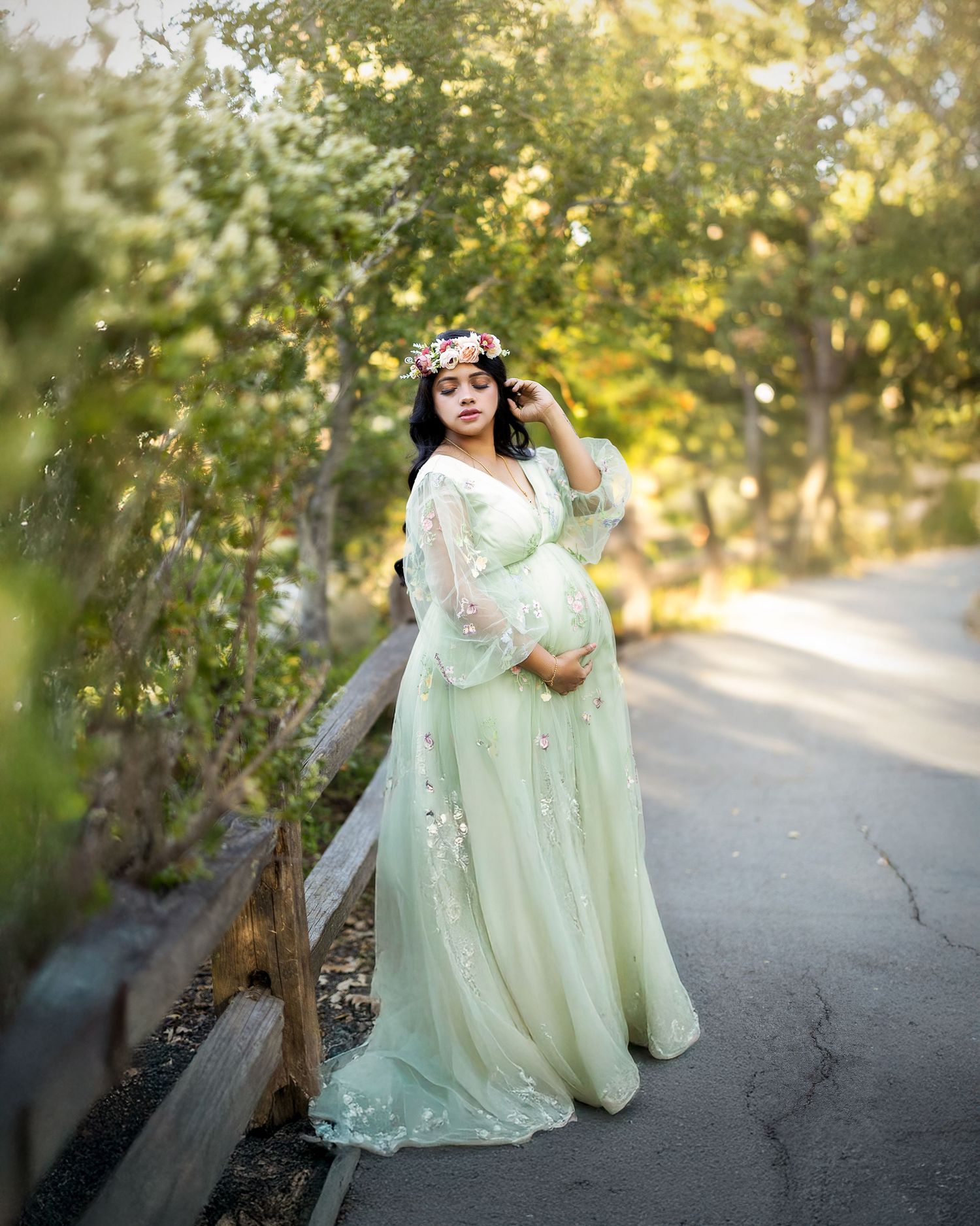 A dreamy outdoor portrait session featuring someone in a flowing mint green gown surrounded by soft natural lighting.