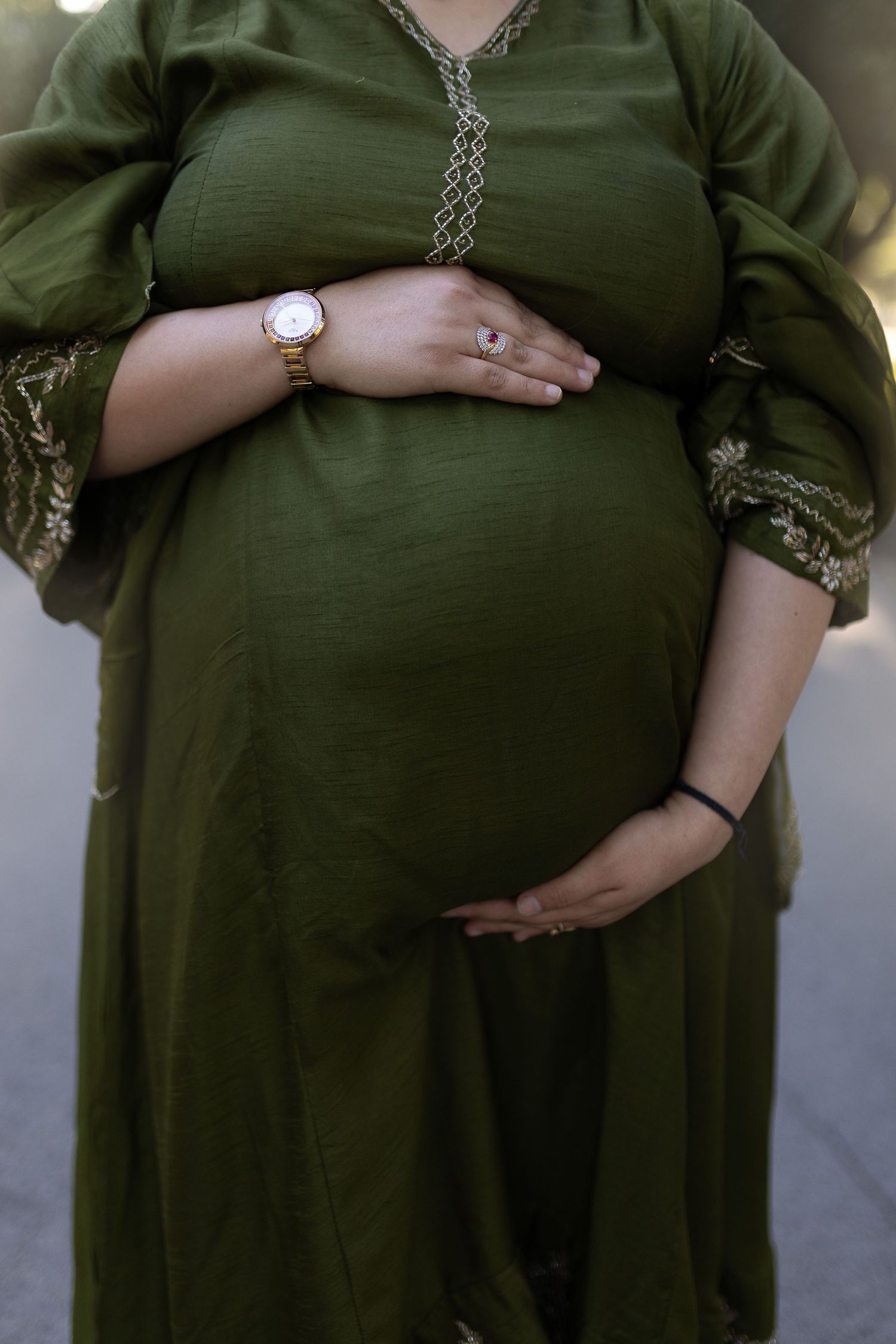 Pregnant woman in olive green dress showing progression of baby bump growth across multiple photos.