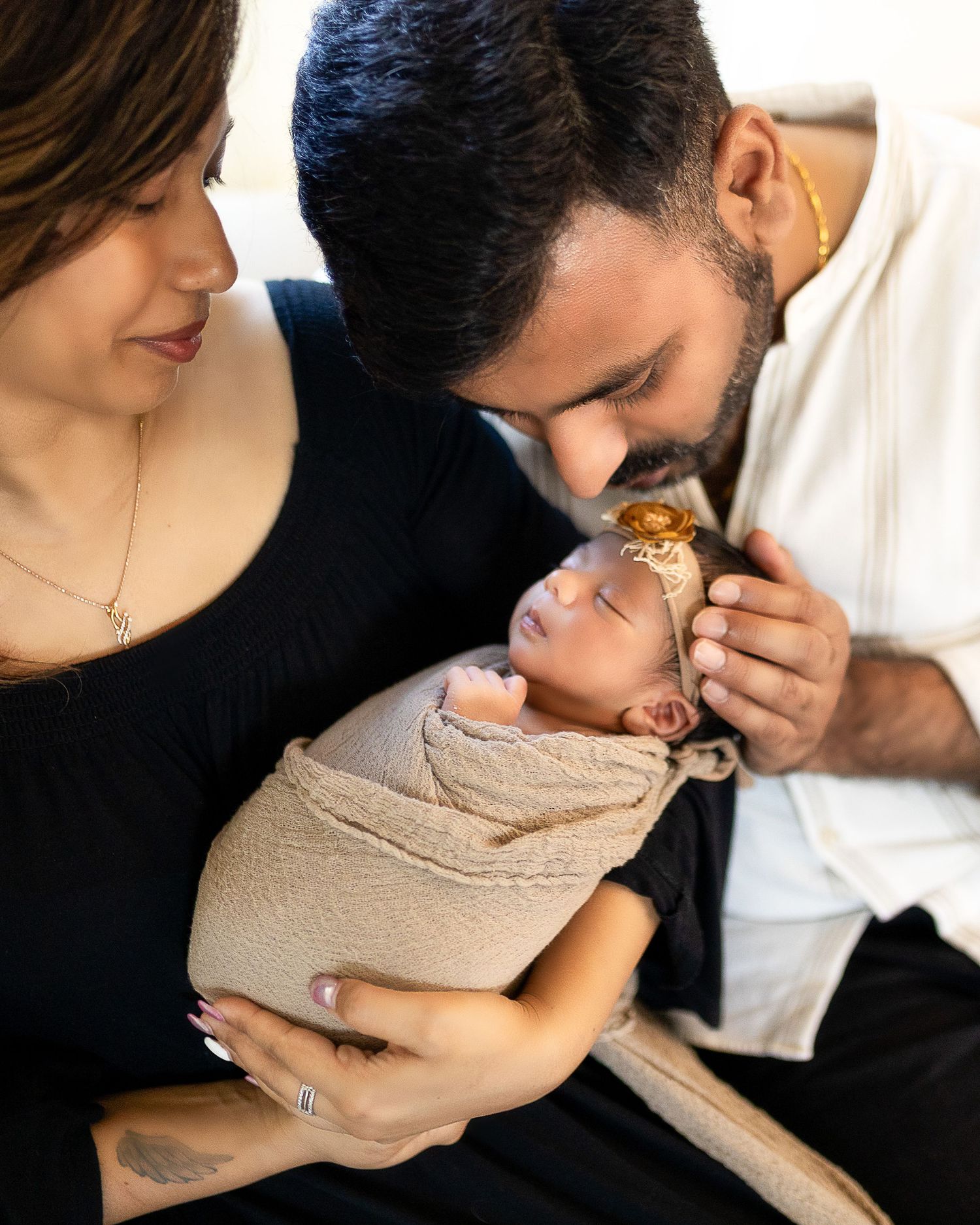 A couple shares tender moments with their newborn baby in a series of intimate black and white photographs.
