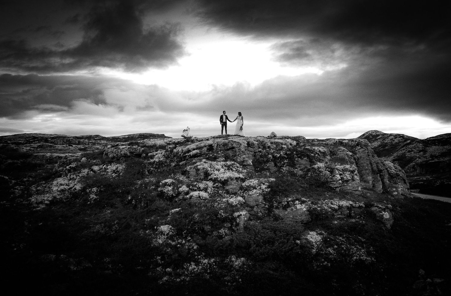 Dramatic panoramic view of silhouettes against a moody sky in a remote mountainous landscape.