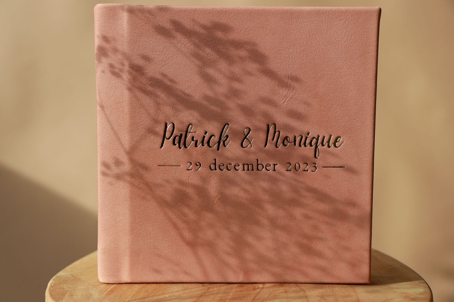 A pink photo album or wedding book with calligraphy text and shadow patterns on its cover, dated December 24, 2023.